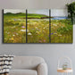 Three-panel canvas wall art featuring rugged coastal cliff landscape, displayed in a modern living room above a sofa.