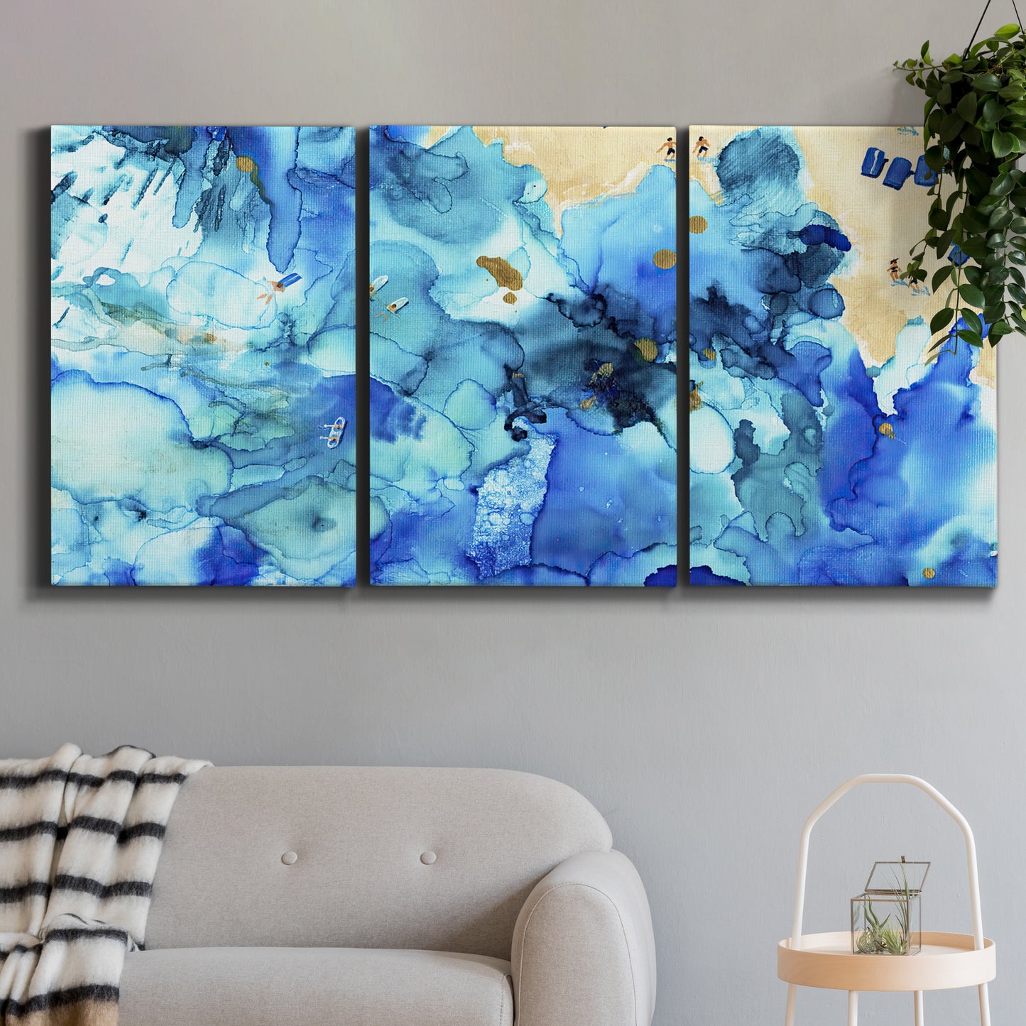 Three-panel canvas wall art featuring abstract coastal beach color fields, displayed in a modern living room above a sofa.
