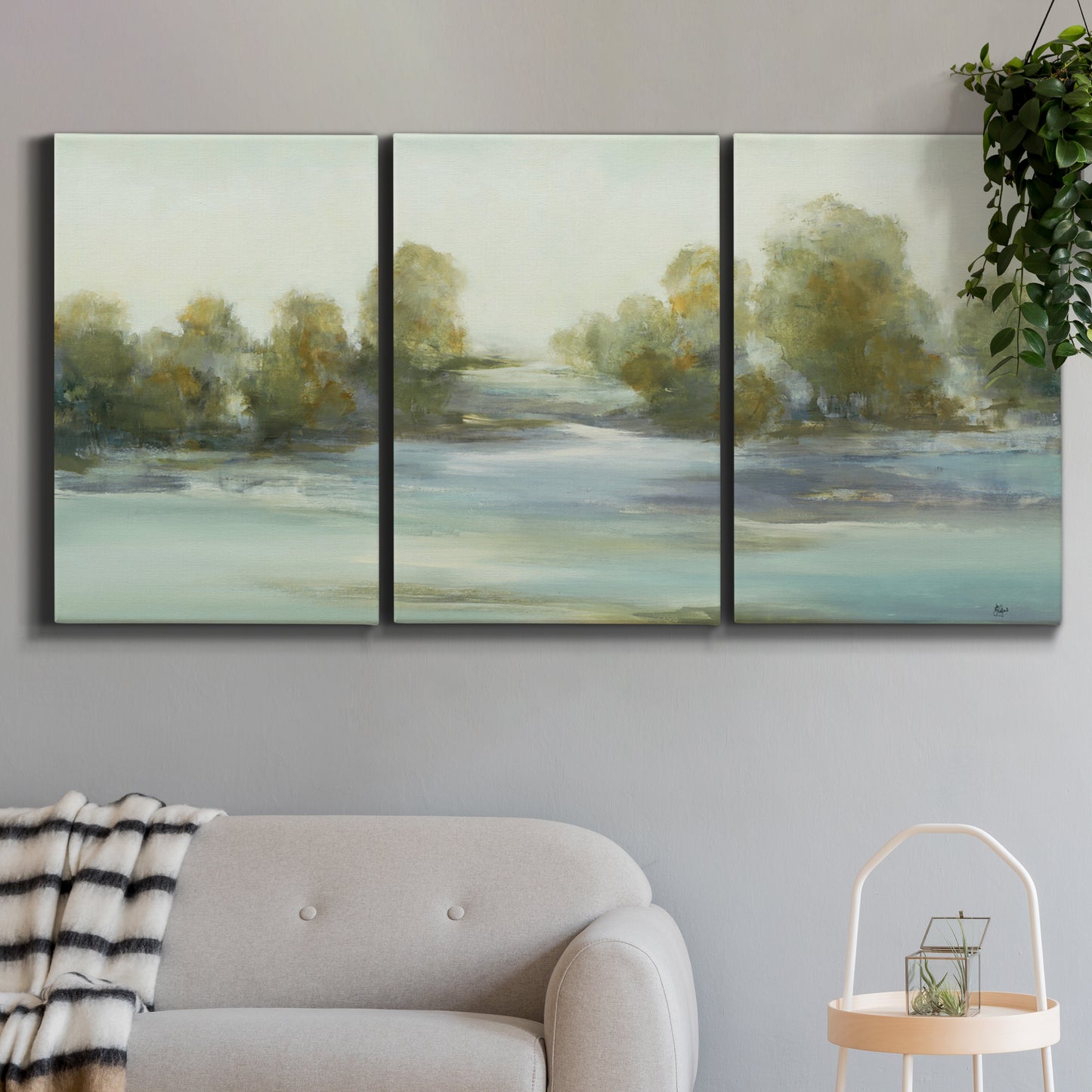 Three-panel canvas wall art featuring calming scenic landscape view, displayed in a modern living room above a sofa.