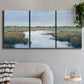 Three-panel canvas wall art featuring coastal plain with layered horizon, displayed in a modern living room above a sofa.