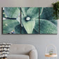 Three-panel canvas wall art featuring green succulent plant photograph, displayed in a modern living room above a sofa.