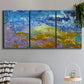 Three-panel canvas wall art featuring expressive abstract with layered color, displayed in a modern living room above a sofa.