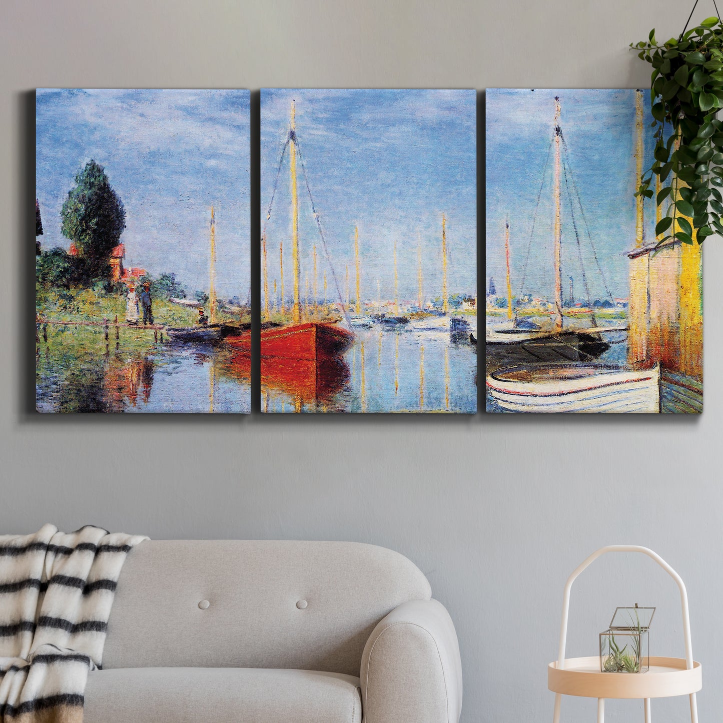 Three-panel canvas wall art featuring sailboats gathered along river, displayed in a modern living room above a sofa.