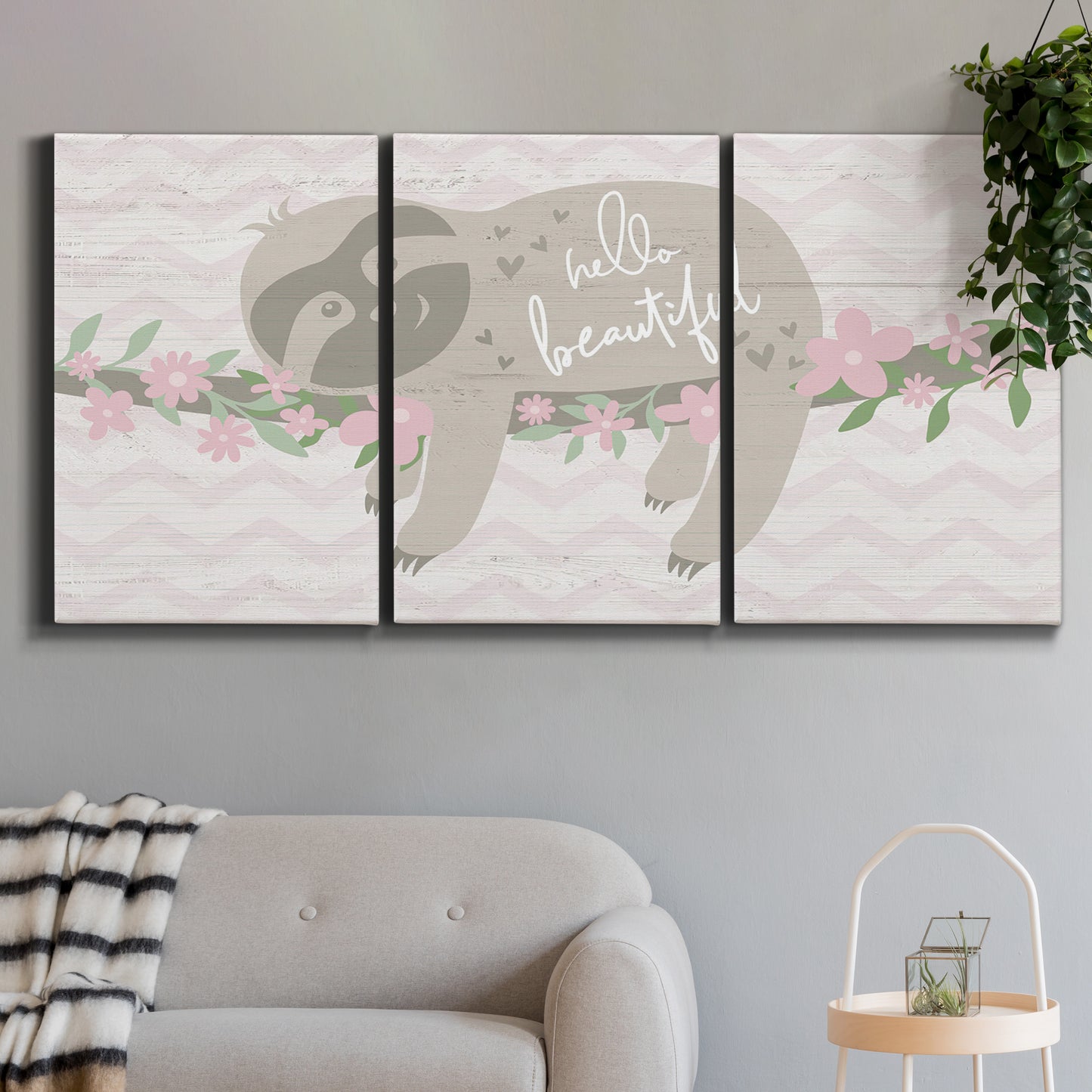 Three-panel canvas wall art featuring sloth with floral decorative elements, displayed in a modern living room above a sofa.