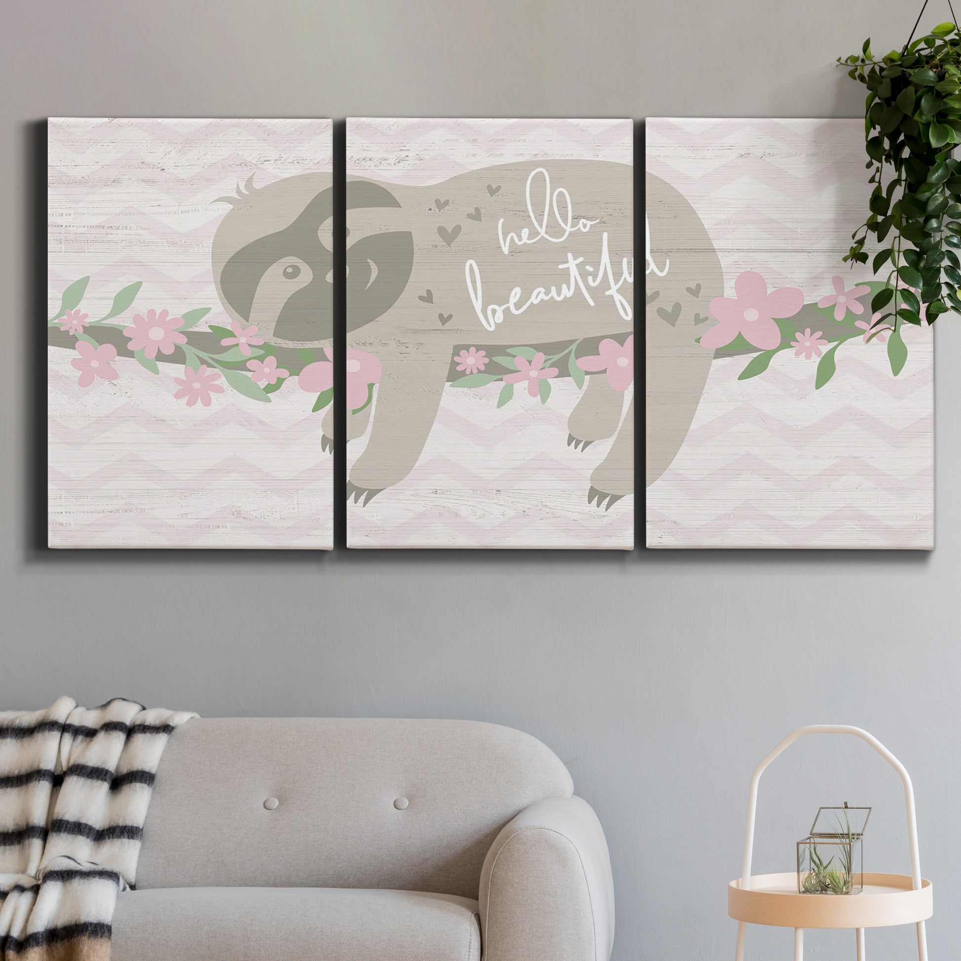 Three-panel canvas wall art featuring sloth with floral decorative elements, displayed in a modern living room above a sofa.