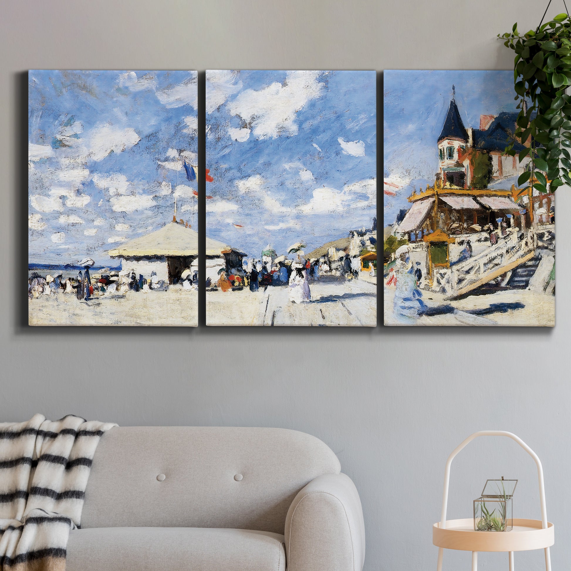 Three-panel canvas wall art featuring beach boardwalk with figures, displayed in a modern living room above a sofa.