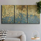 Three-panel canvas wall art featuring metallic abstract gold tones, displayed in a modern living room above a sofa.