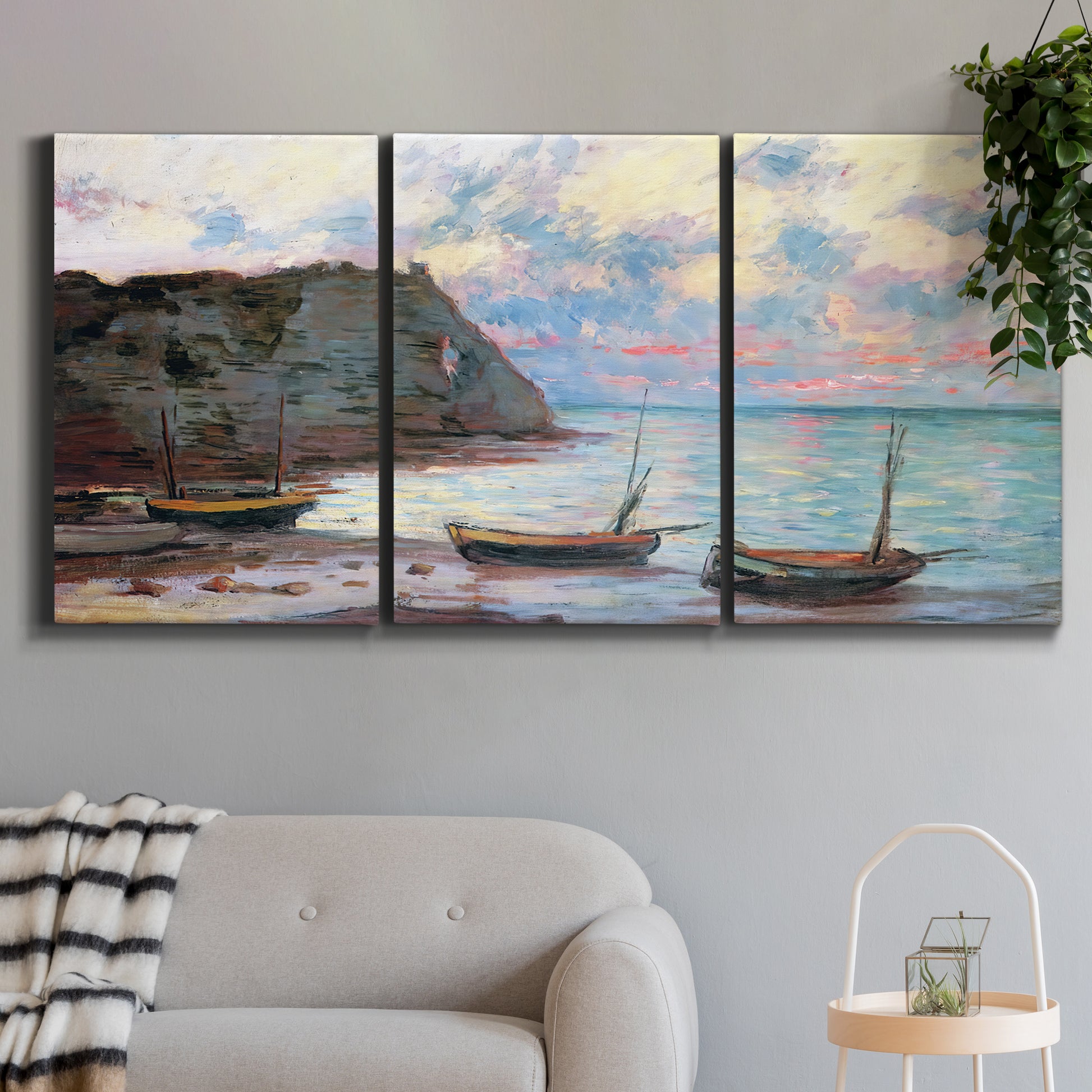 Three-panel canvas wall art featuring golden coastal sunset with cliffs, displayed in a modern living room above a sofa.