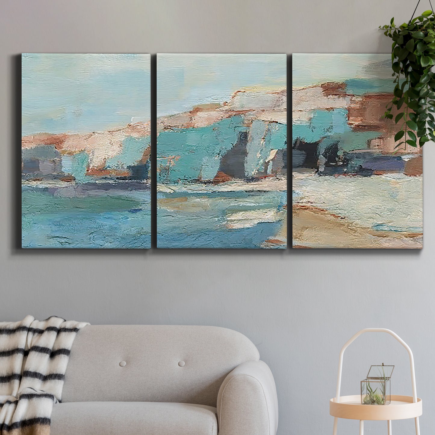 Three-panel canvas wall art featuring coastal shoreline with soft waves, displayed in a modern living room above a sofa.