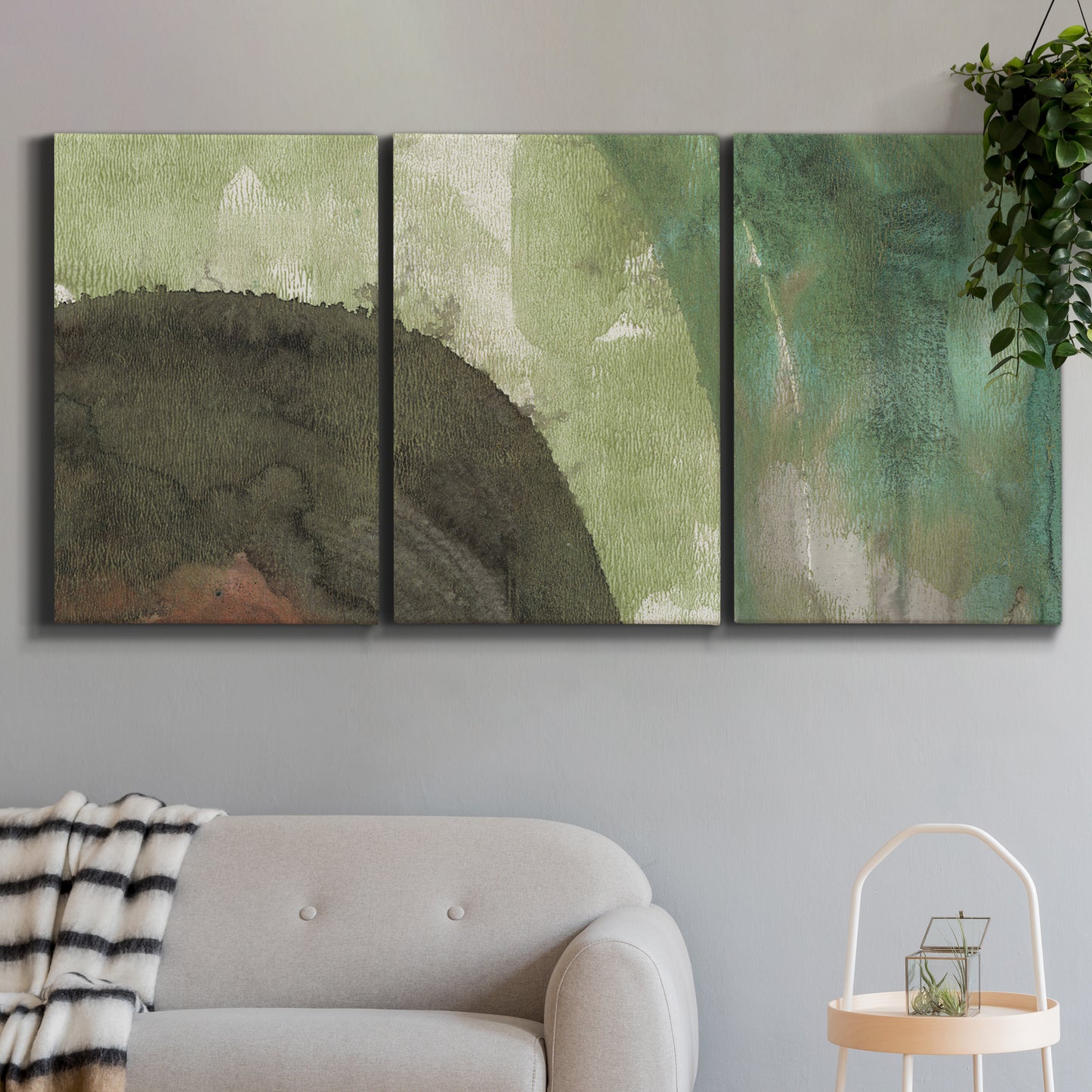 Three-panel canvas wall art featuring layered green abstract composition, displayed in a modern living room above a sofa.