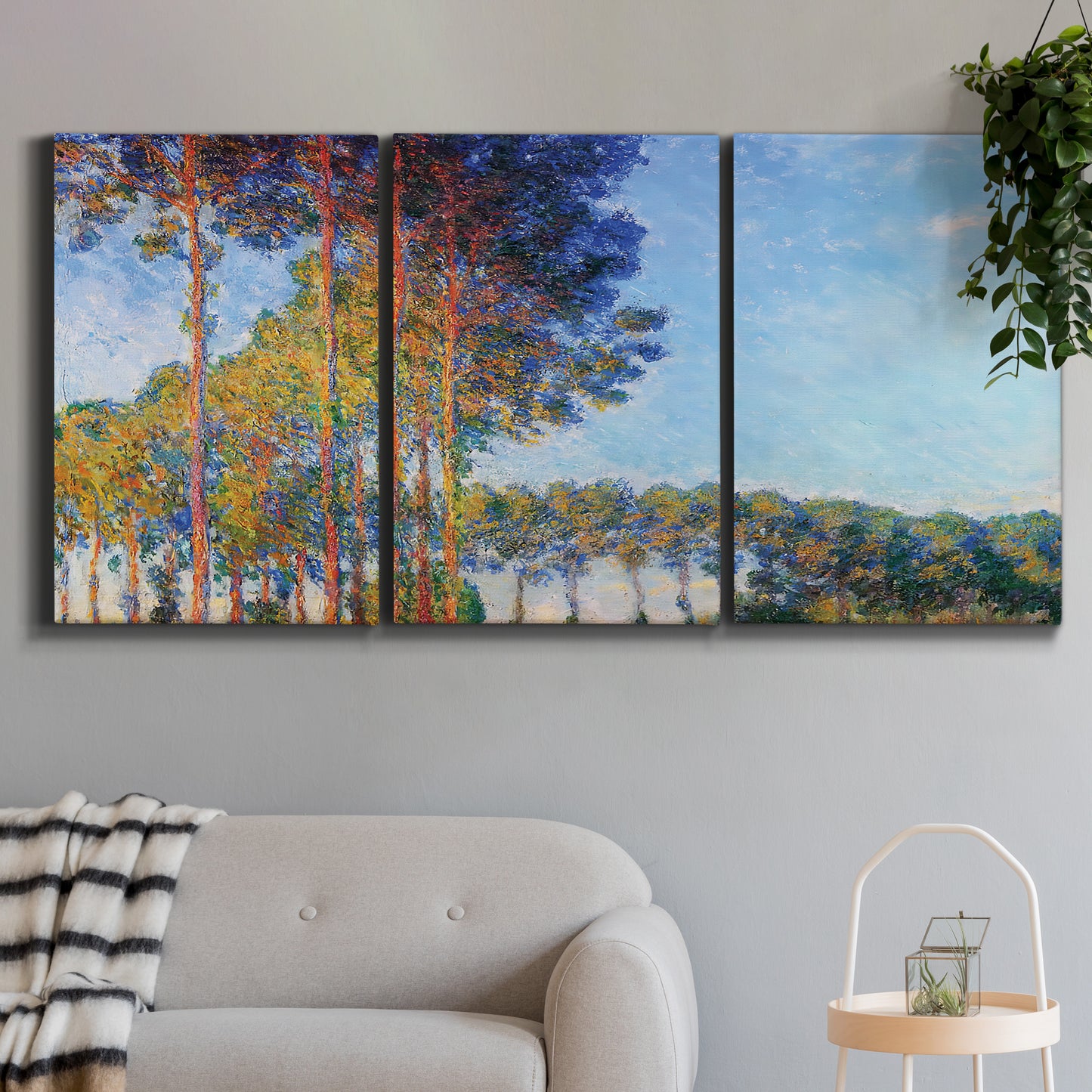 Three-panel canvas wall art featuring autumn poplar trees along river, displayed in a modern living room above a sofa.