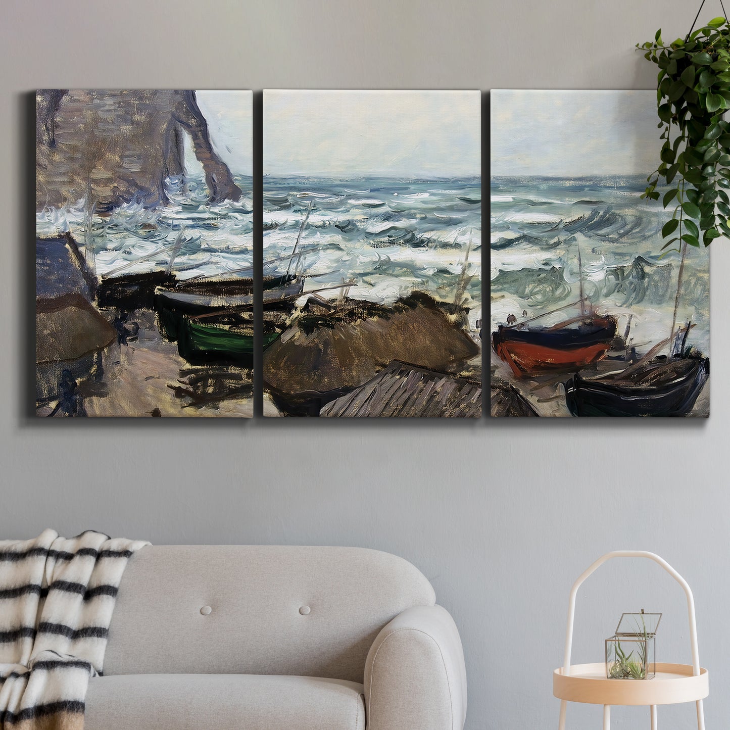Three-panel canvas wall art featuring rough coastal seas under storm clouds, displayed in a modern living room above a sofa.