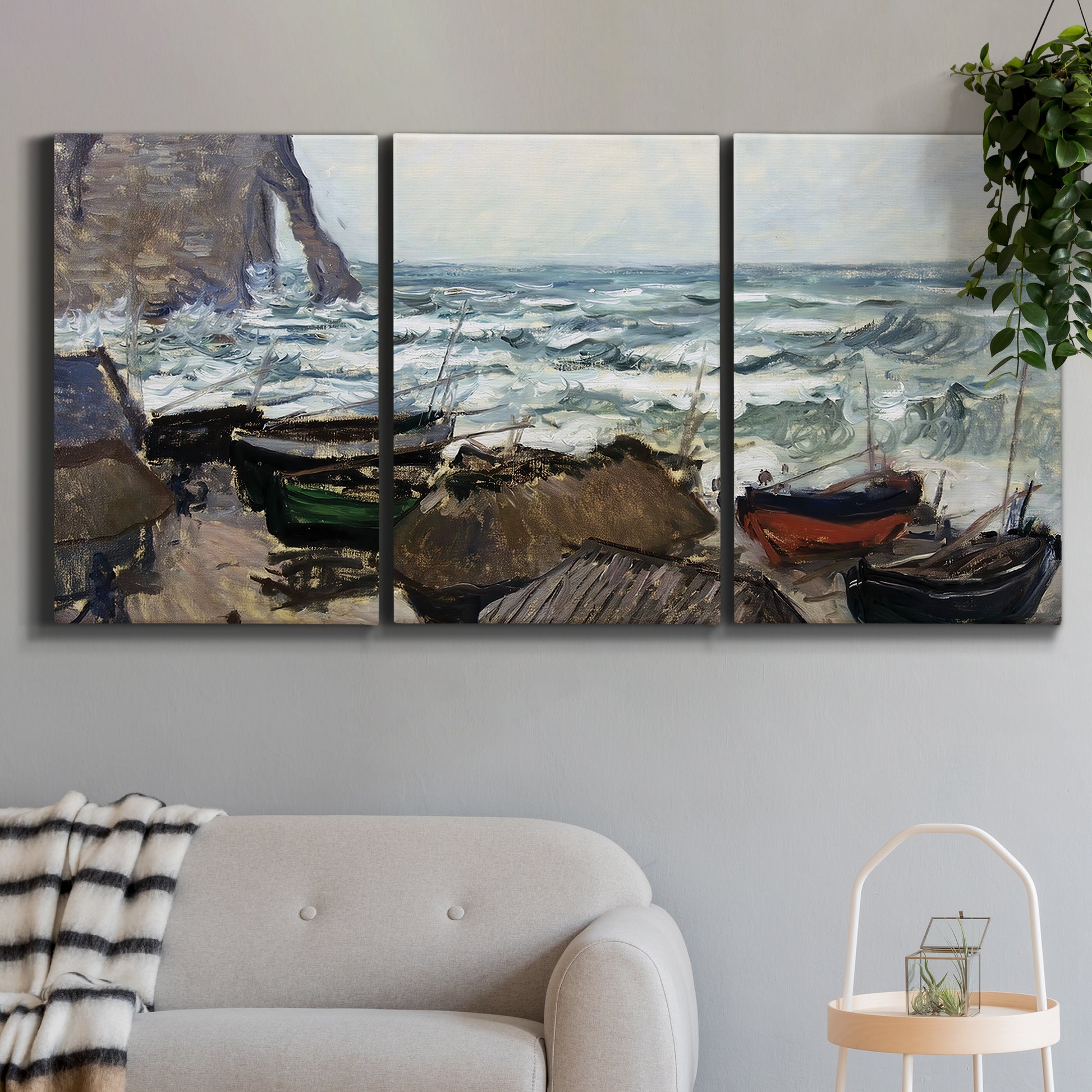 Three-panel canvas wall art featuring rough coastal seas under storm clouds, displayed in a modern living room above a sofa.