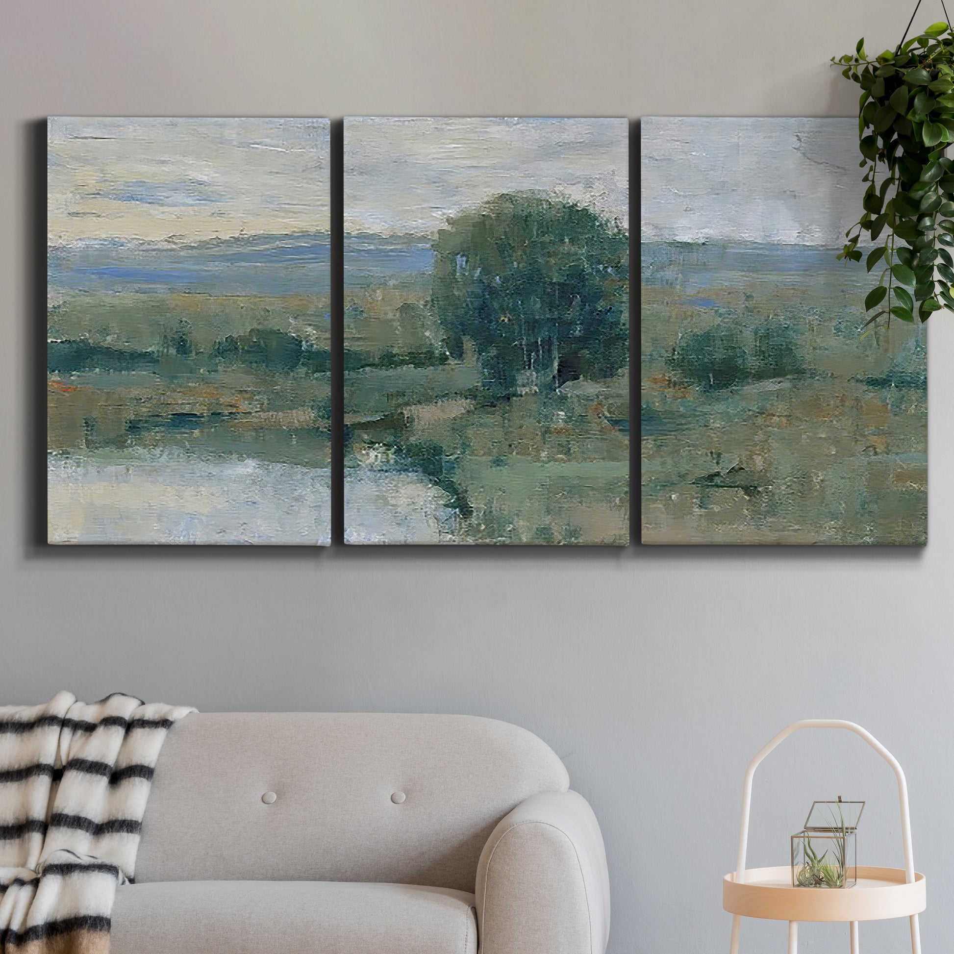Three-panel canvas wall art featuring riverbank landscape with reflections, displayed in a modern living room above a sofa.