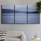 Three-panel canvas wall art featuring calm blue water landscape, displayed in a modern living room above a sofa.