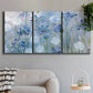 Three-panel canvas wall art featuring delicate watercolor floral blooms, displayed in a modern living room above a sofa.