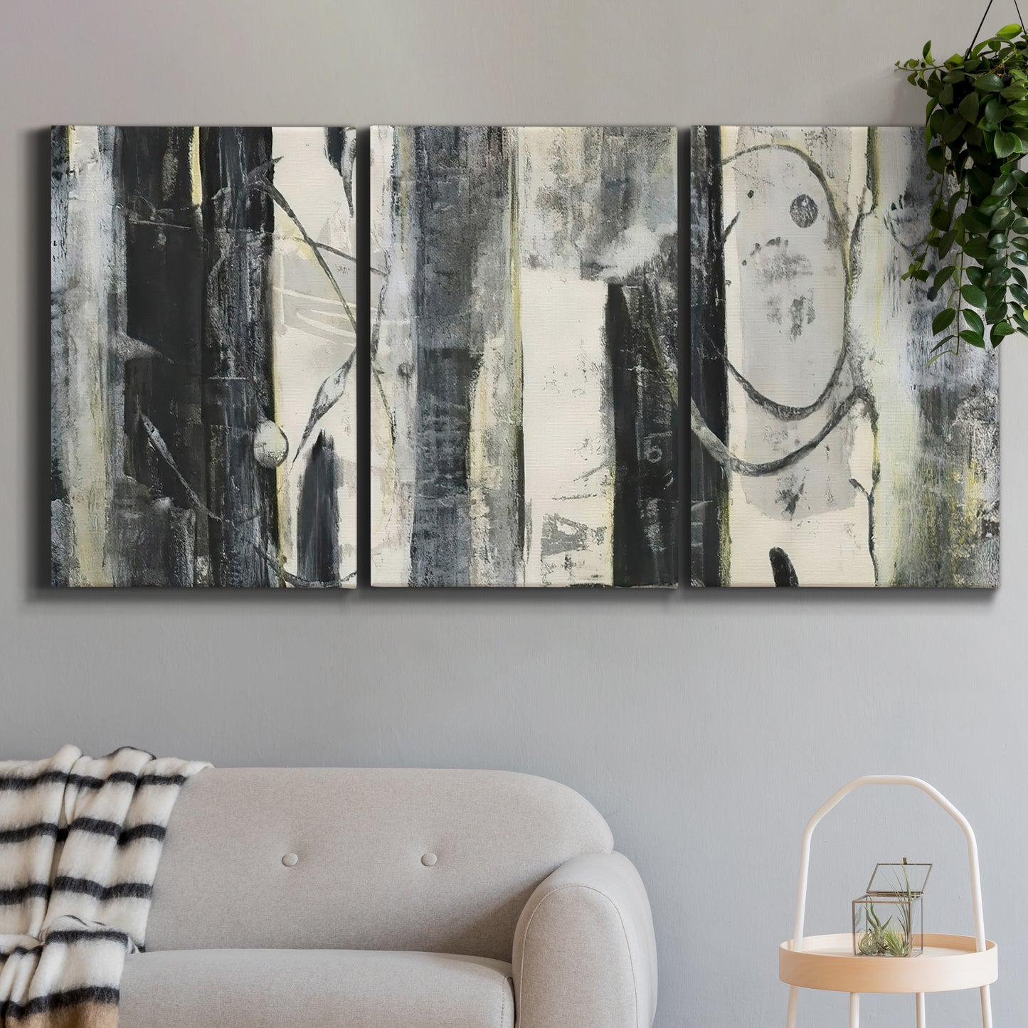 Three-panel canvas wall art featuring vertical abstract tree forms, displayed in a modern living room above a sofa.