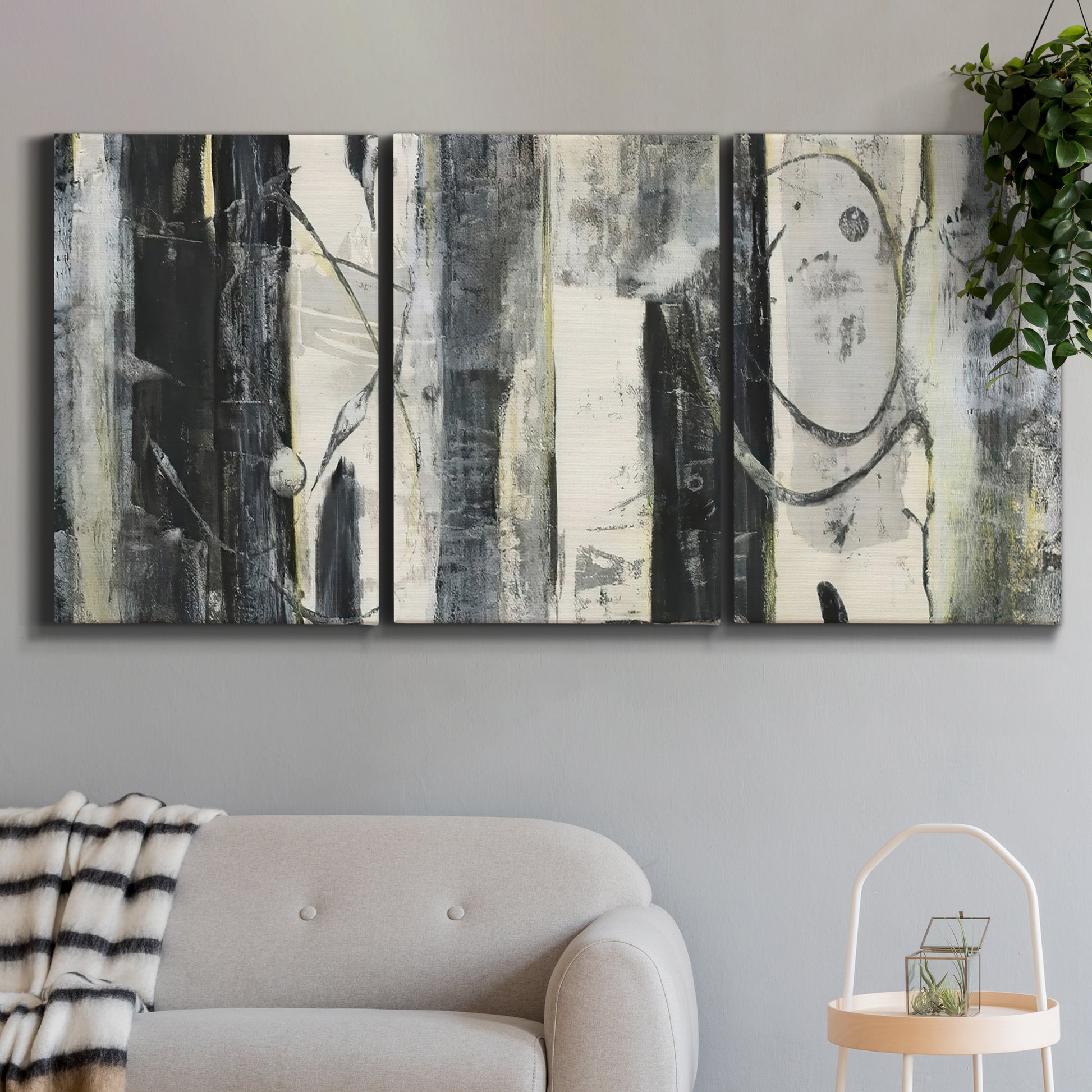 Three-panel canvas wall art featuring vertical abstract tree forms, displayed in a modern living room above a sofa.