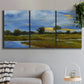 Three-panel canvas wall art featuring riverside walking path through greenery, displayed in a modern living room above a sofa.