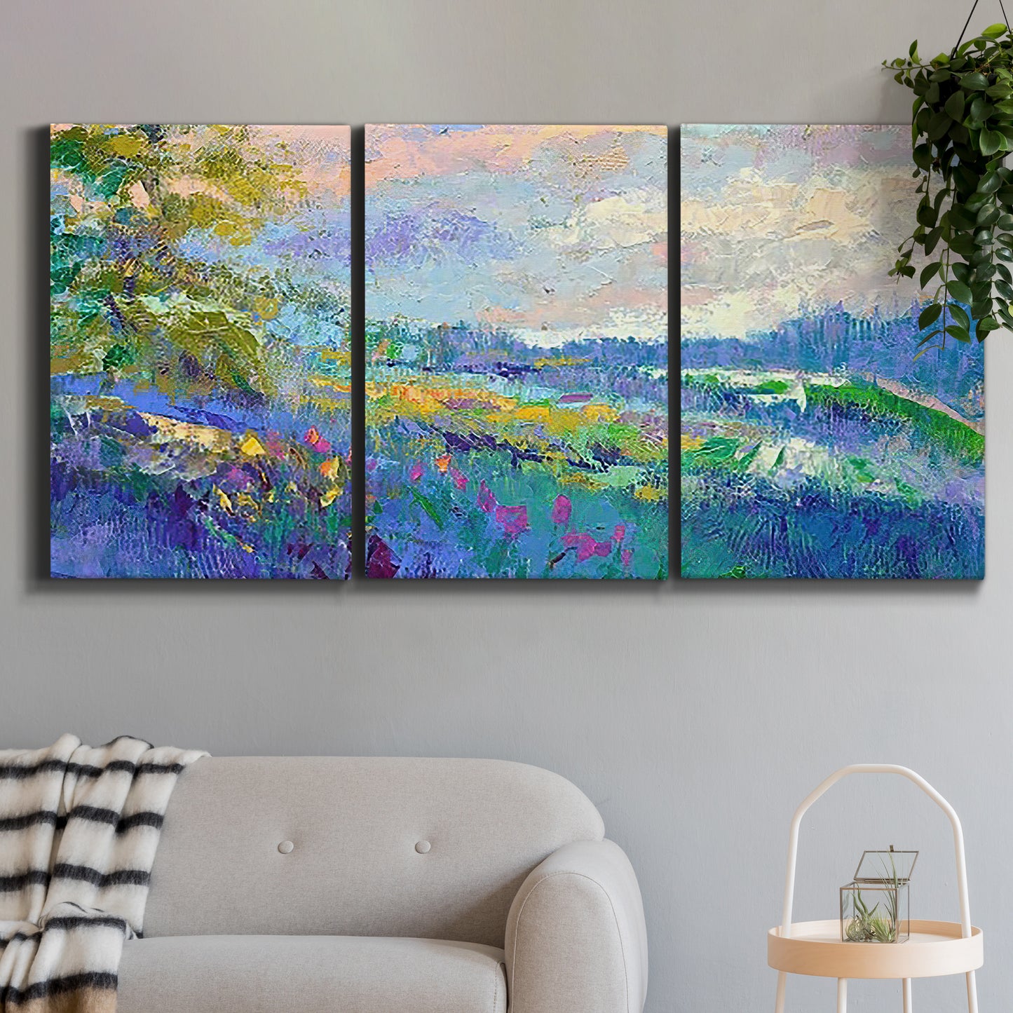 Three-panel canvas wall art featuring cheerful landscape under open sky, displayed in a modern living room above a sofa.
