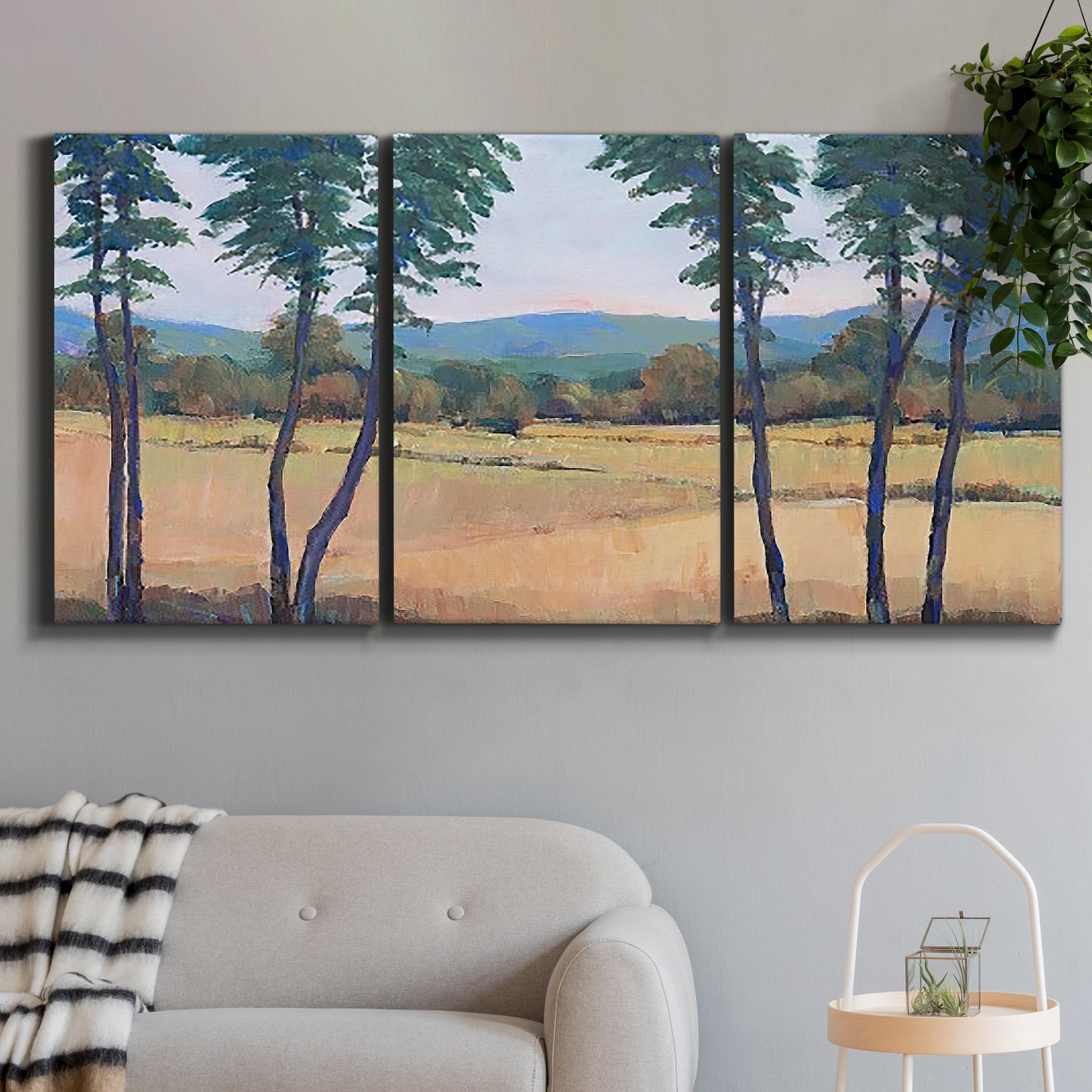 Three-panel canvas wall art featuring quiet morning landscape with trees, displayed in a modern living room above a sofa.