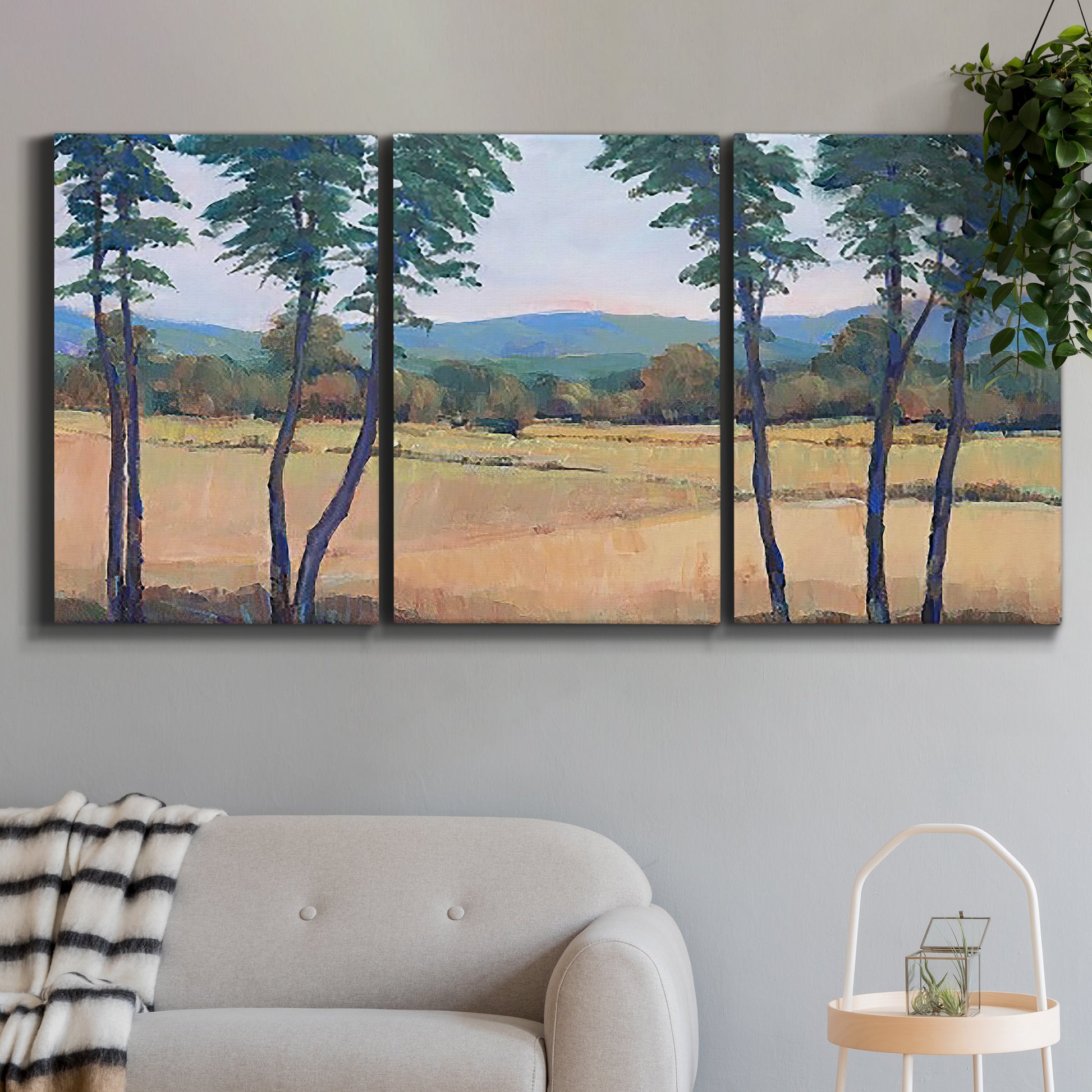 Three-panel canvas wall art featuring quiet morning landscape with trees, displayed in a modern living room above a sofa.