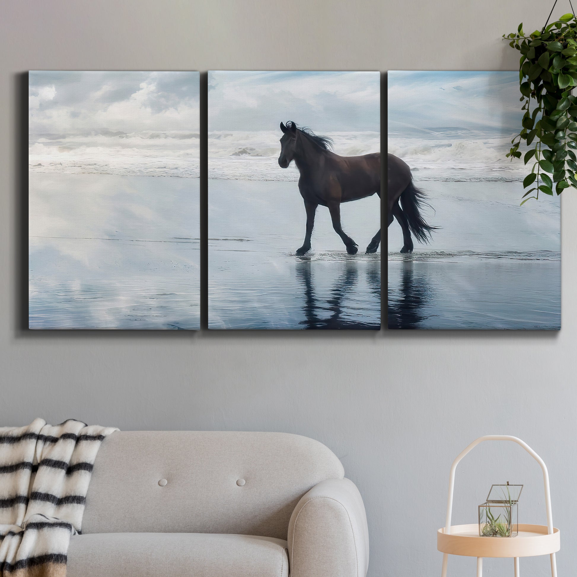 Three-panel canvas wall art featuring running horses captured mid stride, displayed in a modern living room above a sofa.
