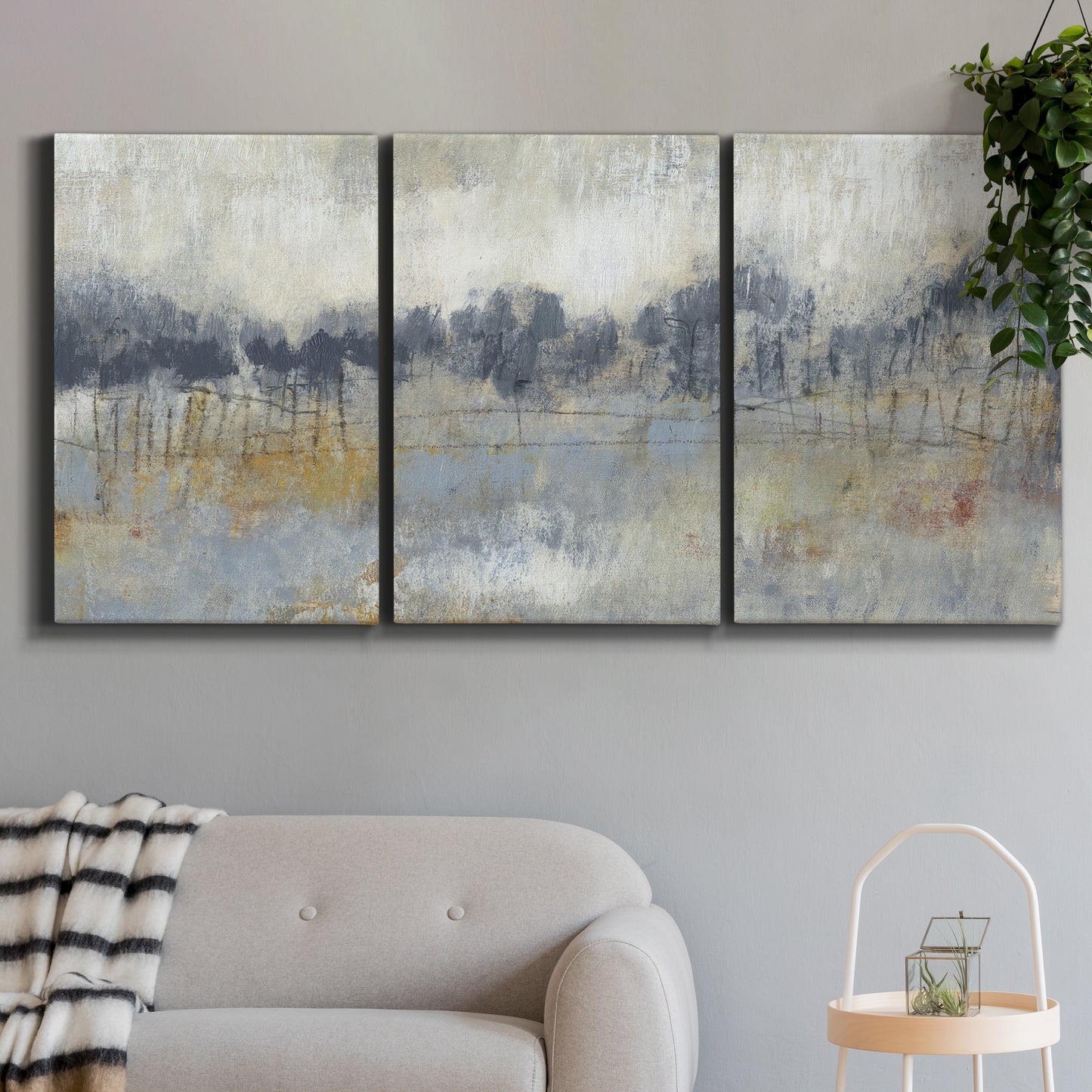 Three-panel canvas wall art featuring soft grey abstract horizon, displayed in a modern living room above a sofa.