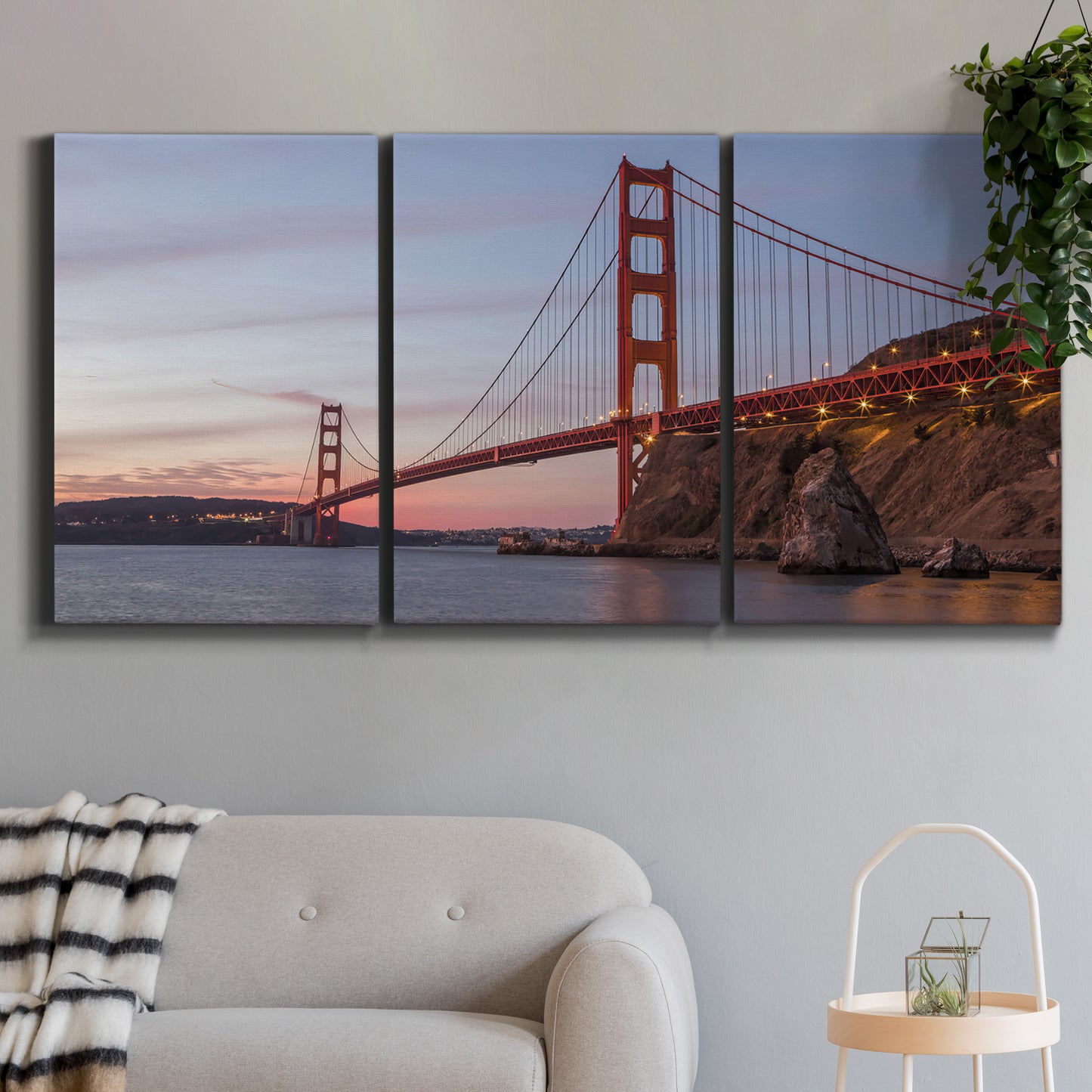 Three-panel canvas wall art featuring golden gate bridge spanning bay, displayed in a modern living room above a sofa.