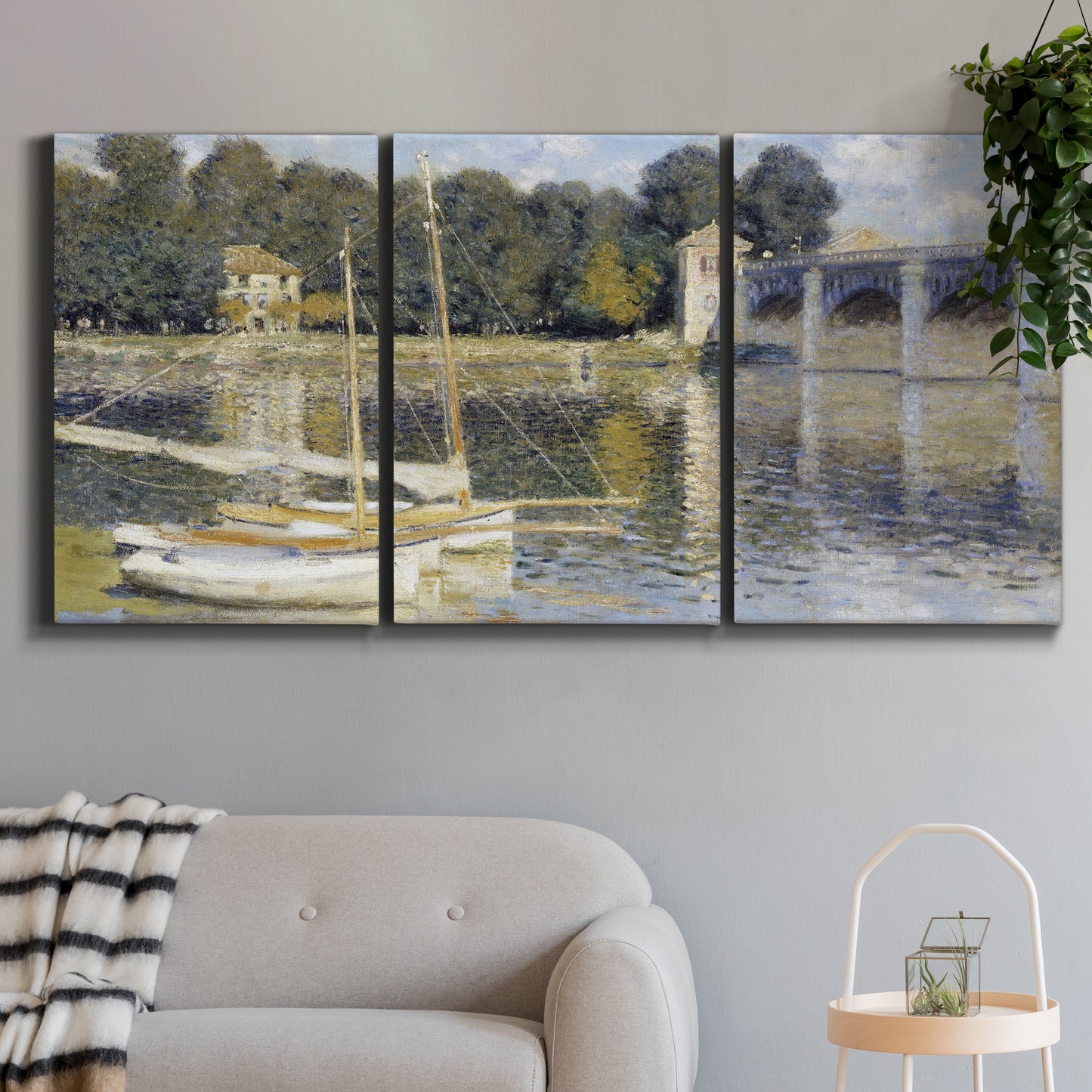 Three-panel canvas wall art featuring bridge crossing broad river, displayed in a modern living room above a sofa.