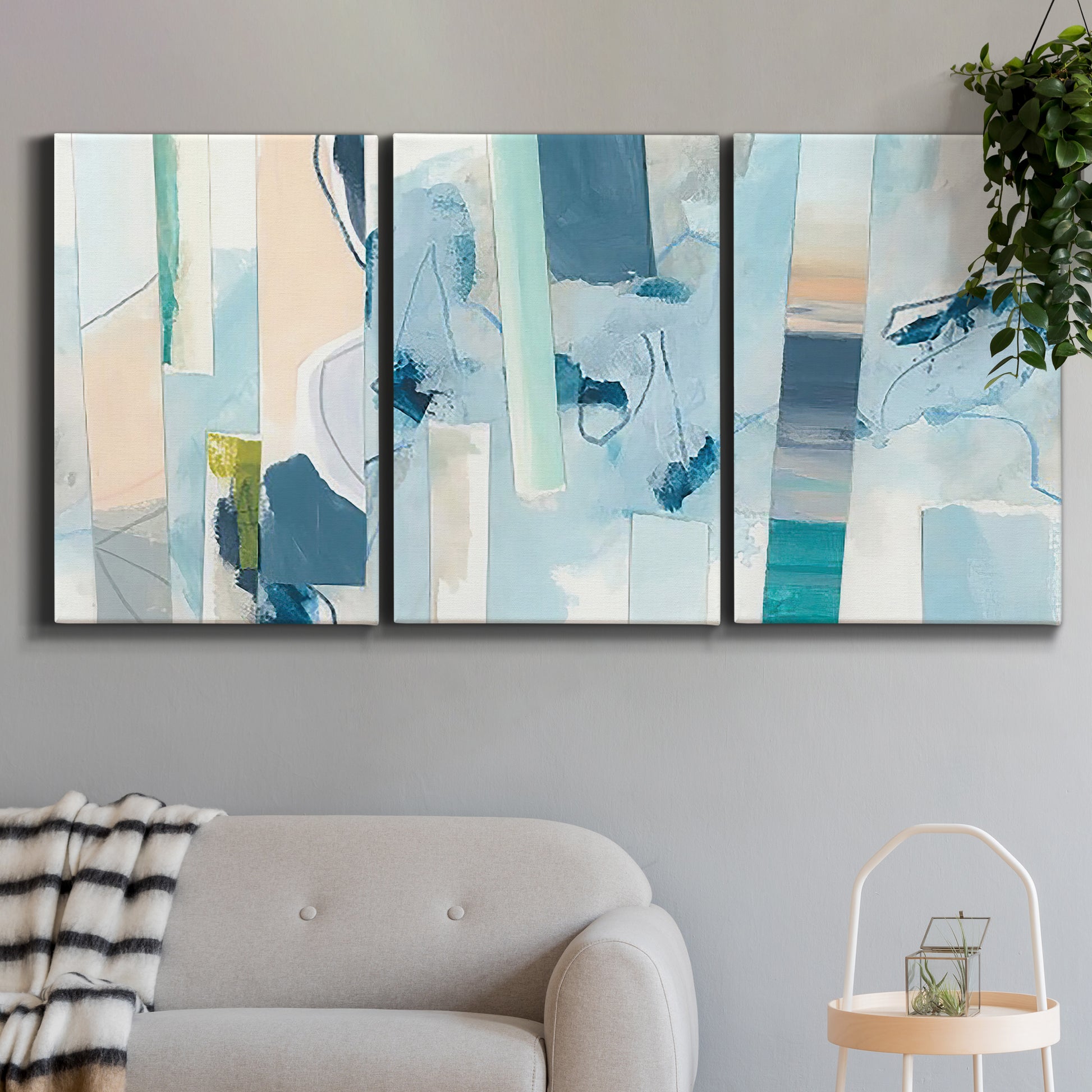 Three-panel canvas wall art featuring layered geometric abstract strata forms, displayed in a modern living room above a sofa.