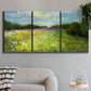 Three-panel canvas wall art featuring pastoral field with wildflowers, displayed in a modern living room above a sofa.