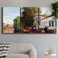 Three-panel canvas wall art featuring riverside houses along canal, displayed in a modern living room above a sofa.