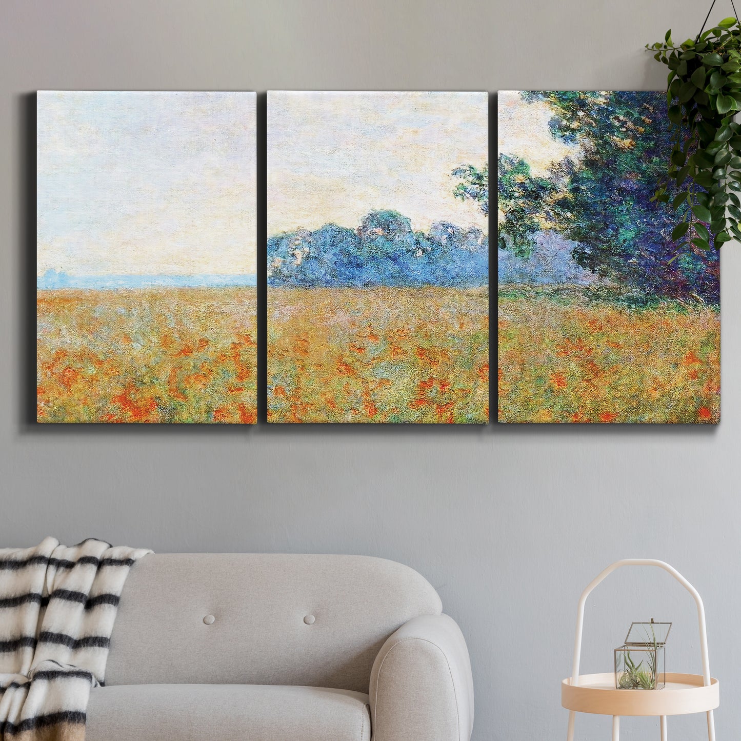 Three-panel canvas wall art featuring oat field with scattered poppies, displayed in a modern living room above a sofa.