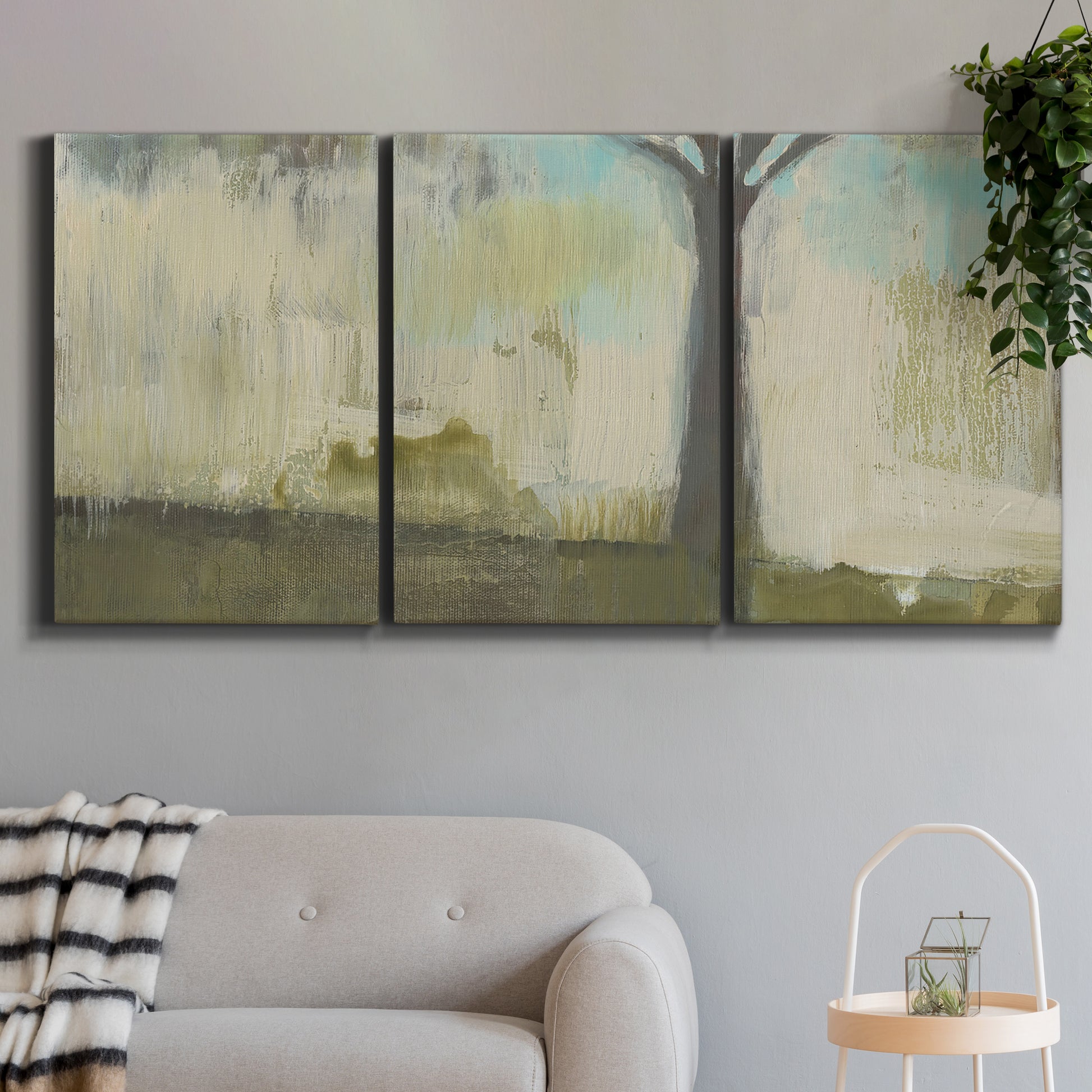 Three-panel canvas wall art featuring tall abstract tree form, displayed in a modern living room above a sofa.