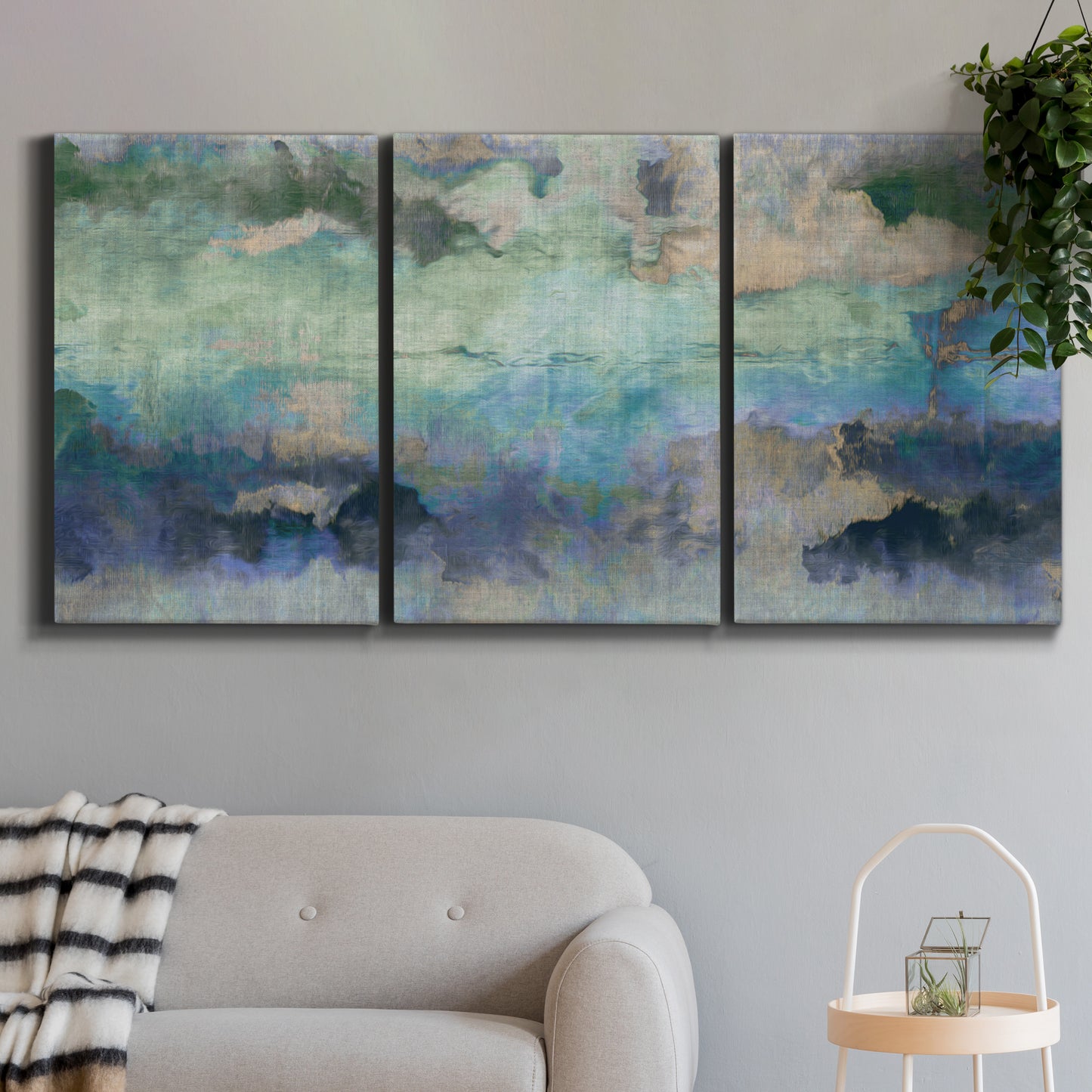 Three-panel canvas wall art featuring cool dreamy abstraction, displayed in a modern living room above a sofa.
