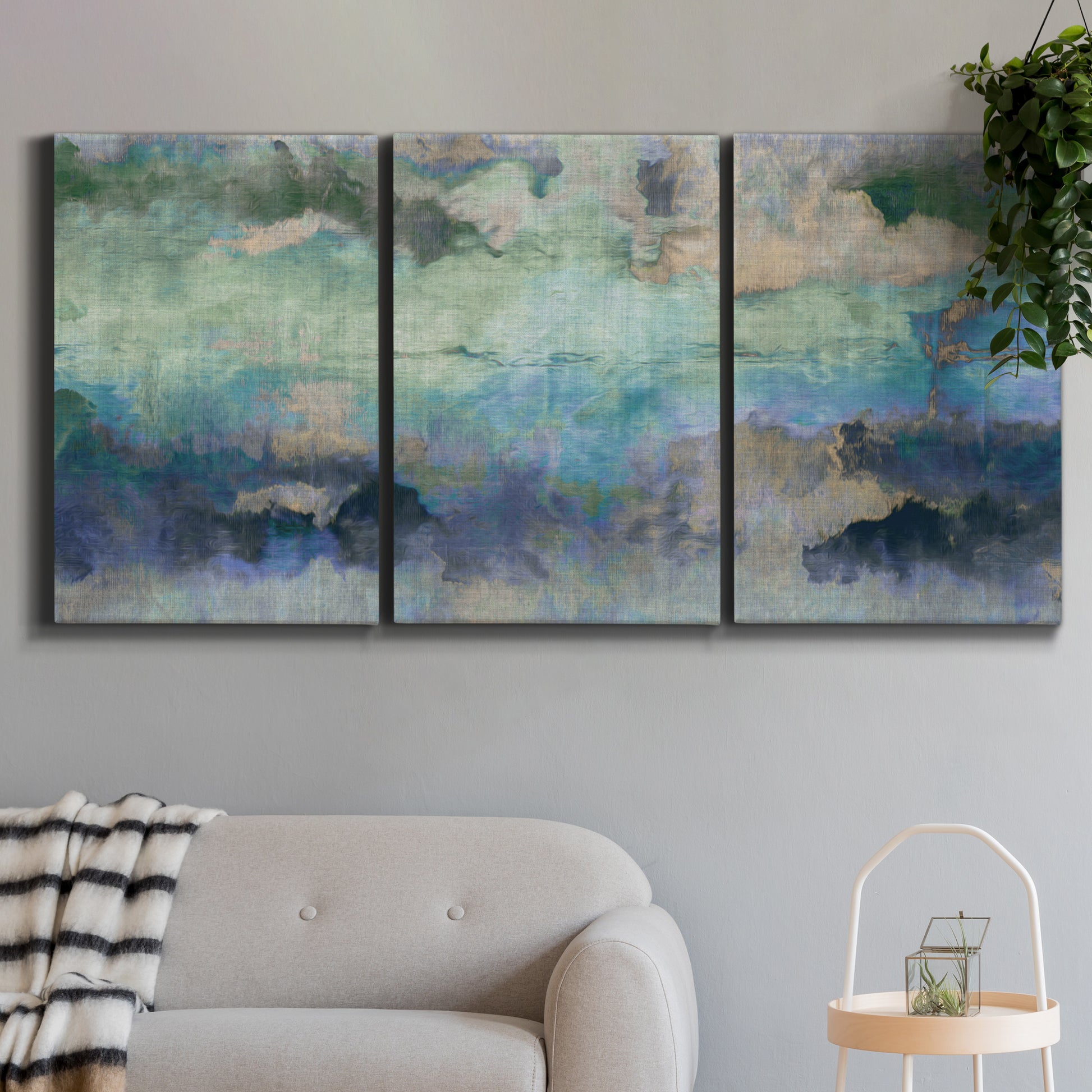 Three-panel canvas wall art featuring cool dreamy abstraction, displayed in a modern living room above a sofa.