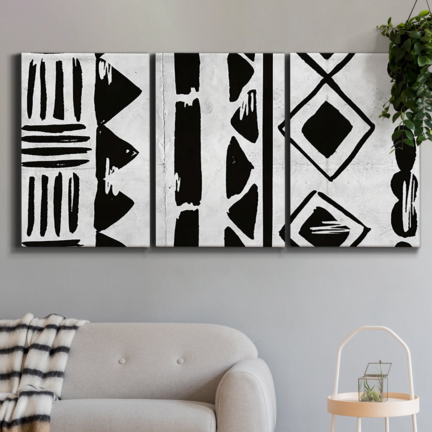 Three-panel canvas wall art featuring geometric abstract forms merging pattern, displayed in a modern living room above a sofa.