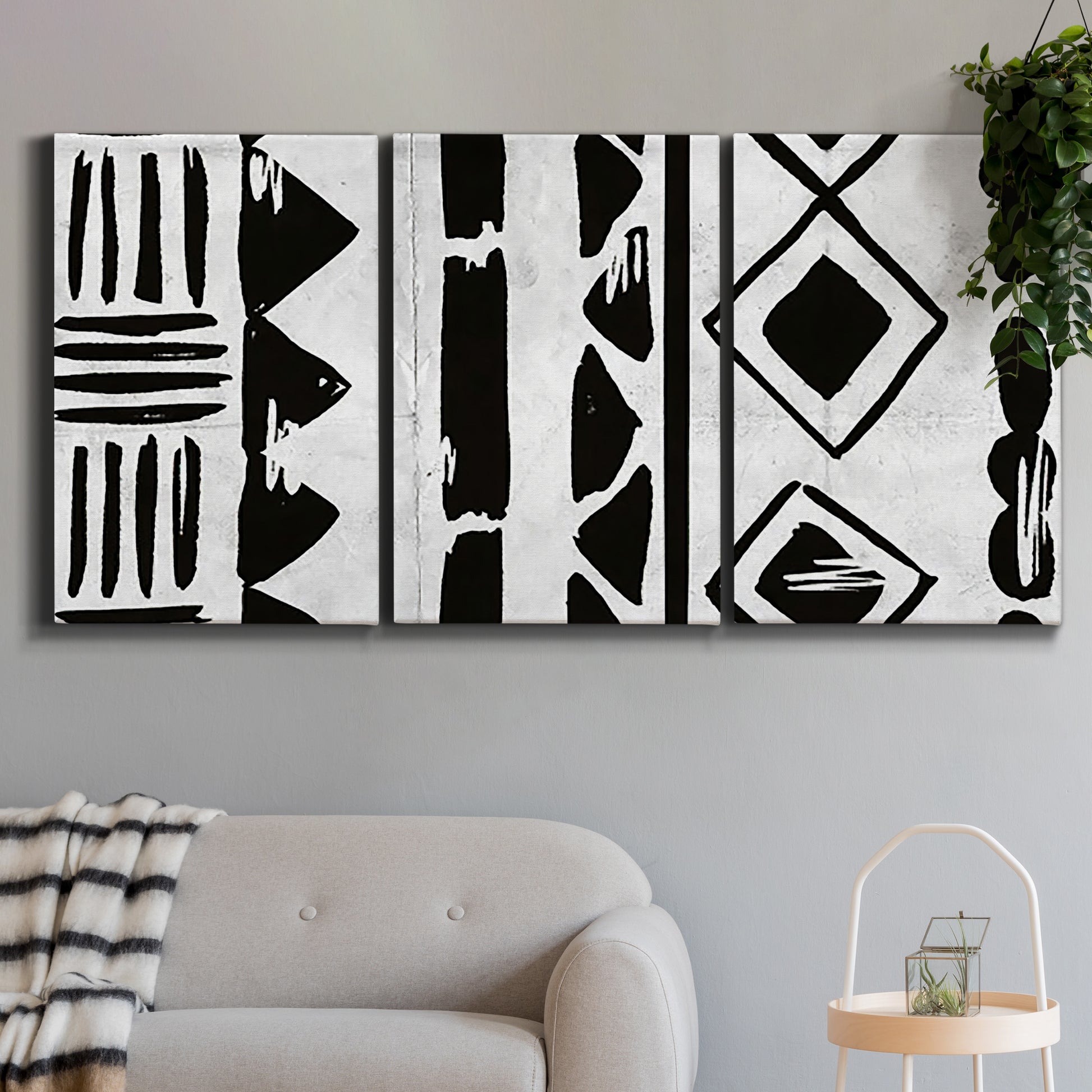 Three-panel canvas wall art featuring geometric abstract forms merging pattern, displayed in a modern living room above a sofa.