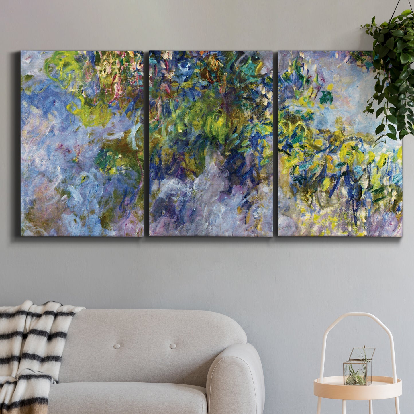 Three-panel canvas wall art featuring cascading purple wisteria blooms, displayed in a modern living room above a sofa.