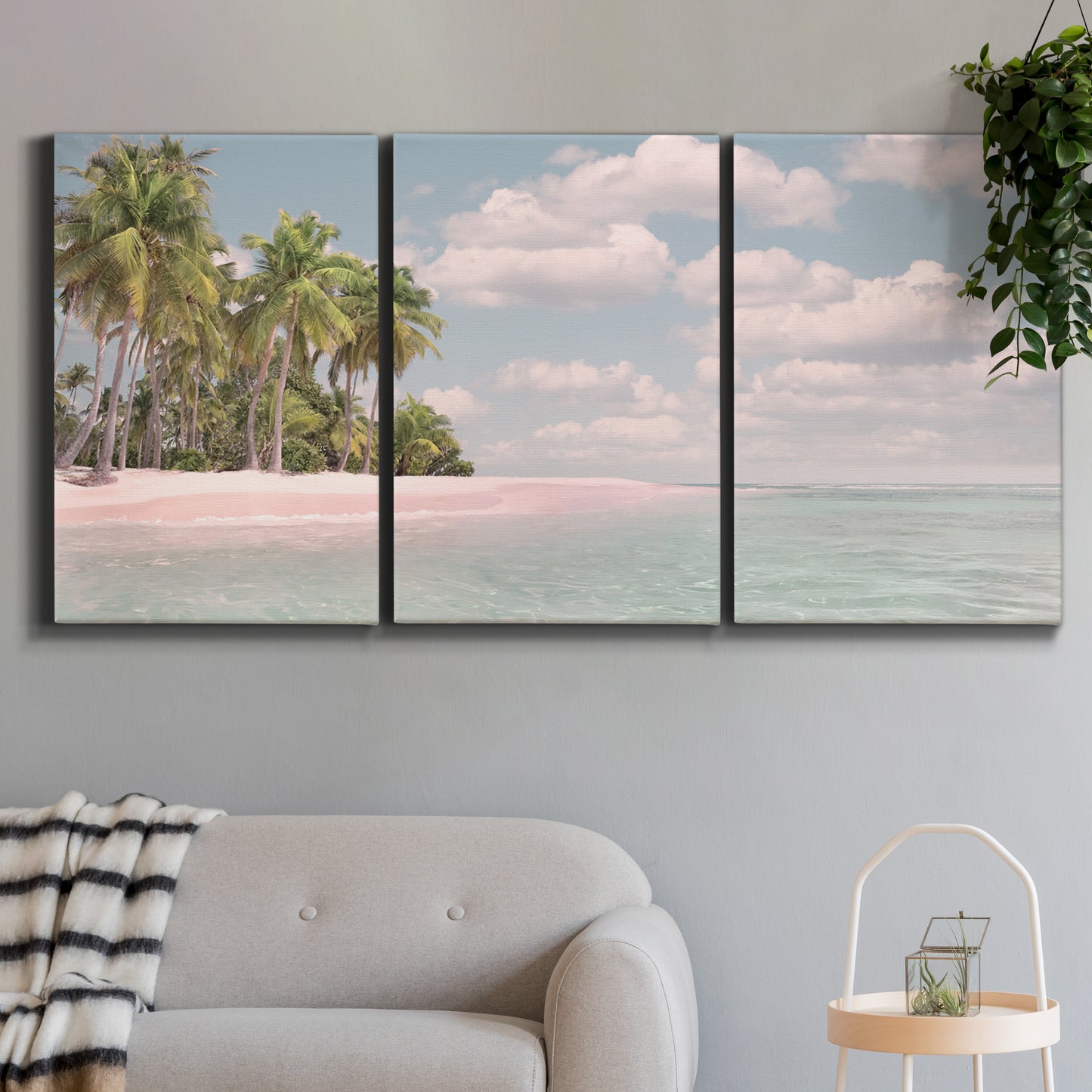Three-panel canvas wall art featuring tropical sand dunes with palms, displayed in a modern living room above a sofa.