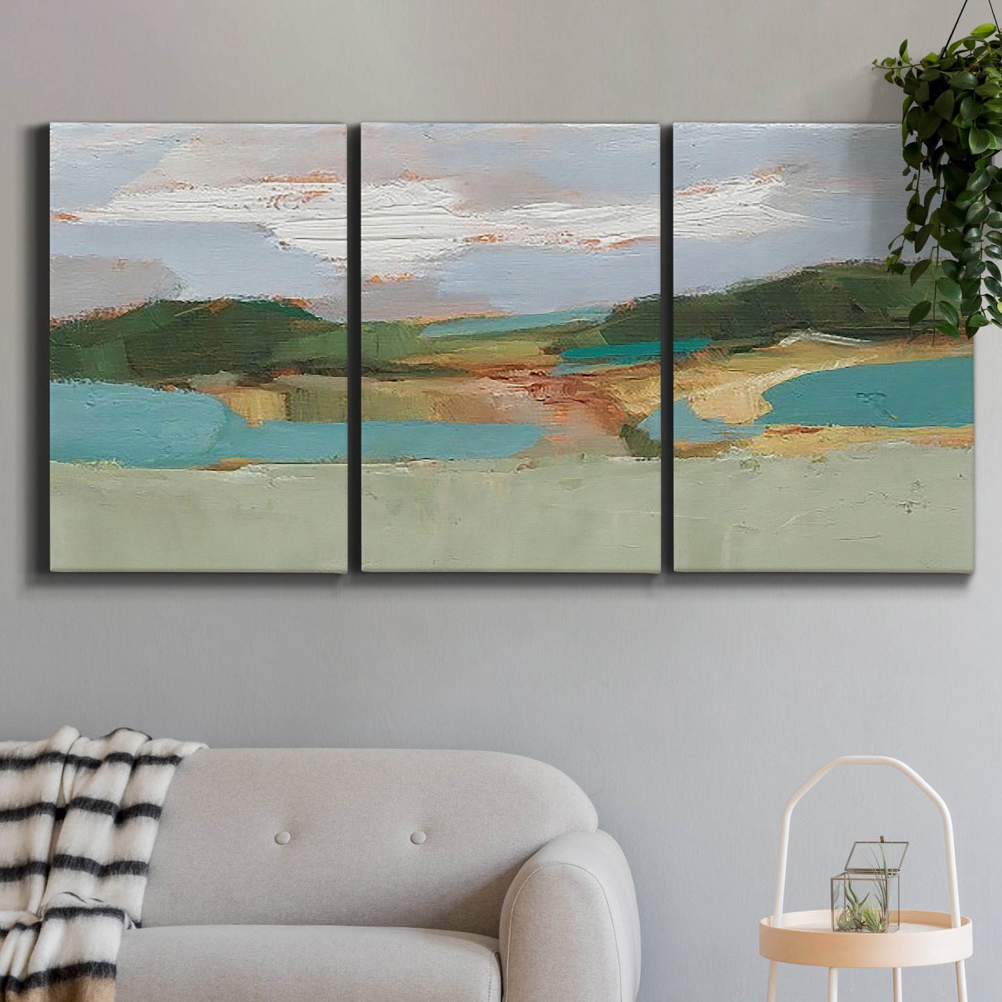 Three-panel canvas wall art featuring wide open landscape under midday light, displayed in a modern living room above a sofa.