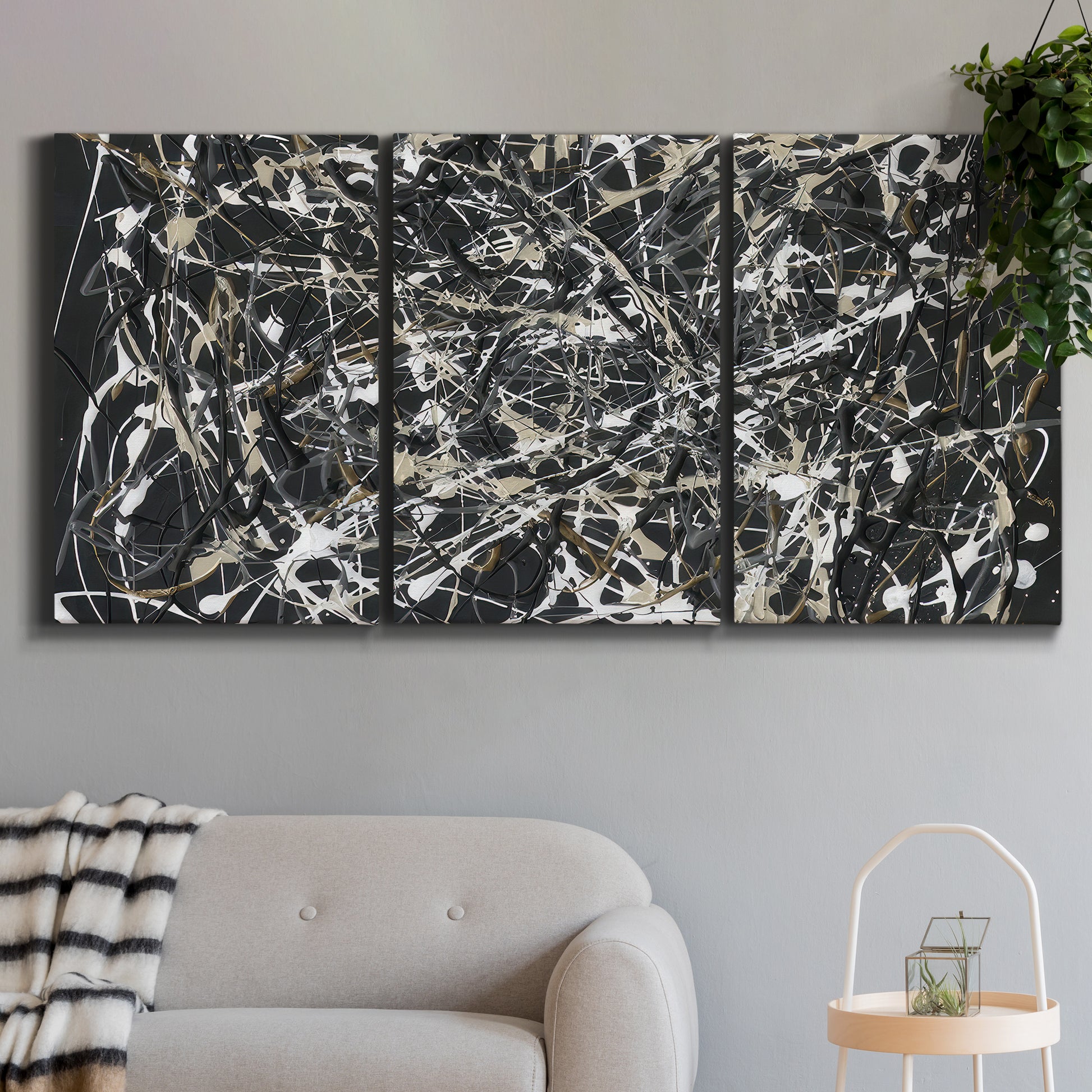 Three-panel canvas wall art featuring energetic expressionist abstract splatter, displayed in a modern living room above a sofa.