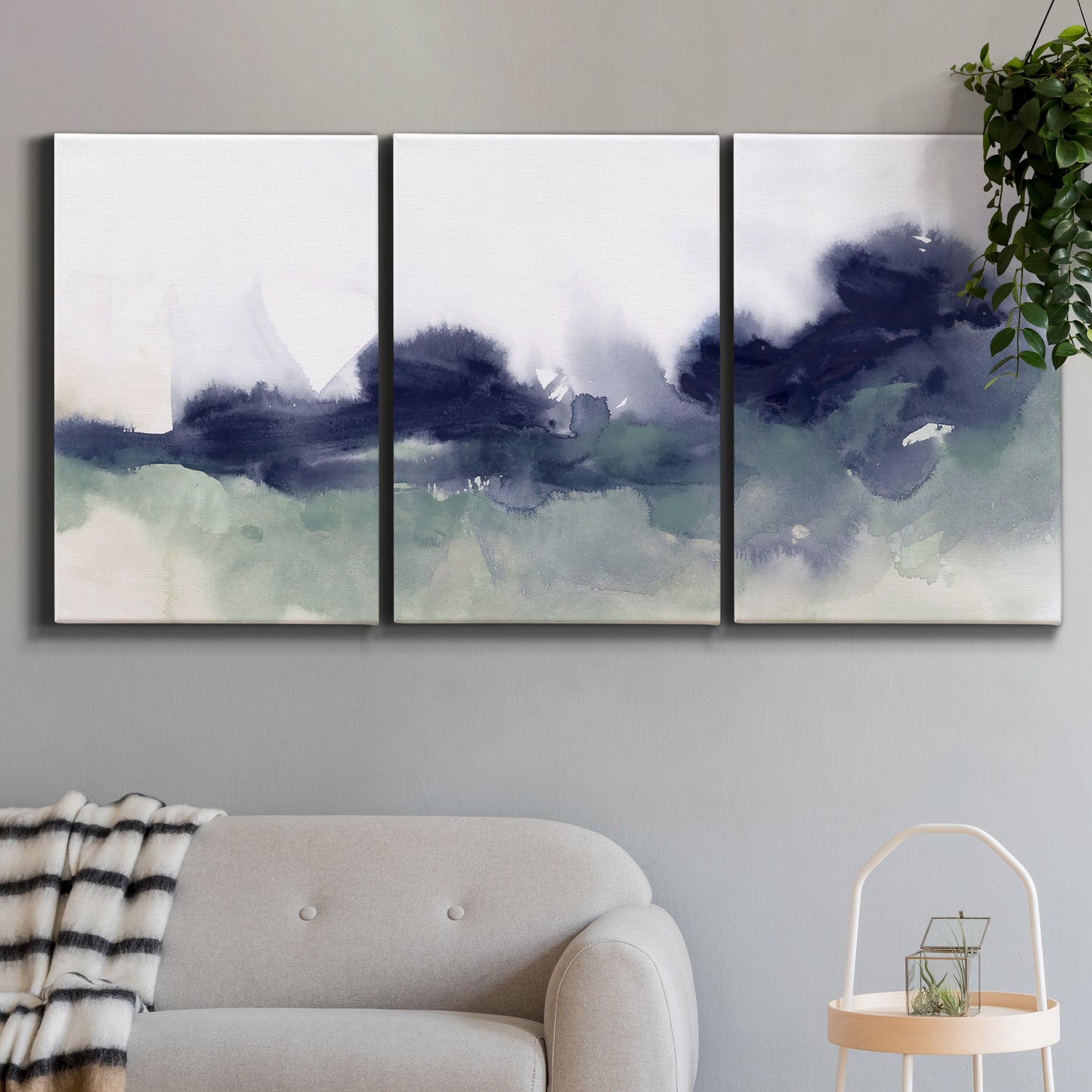 Three-panel canvas wall art featuring misty abstract lake watercolor, displayed in a modern living room above a sofa.