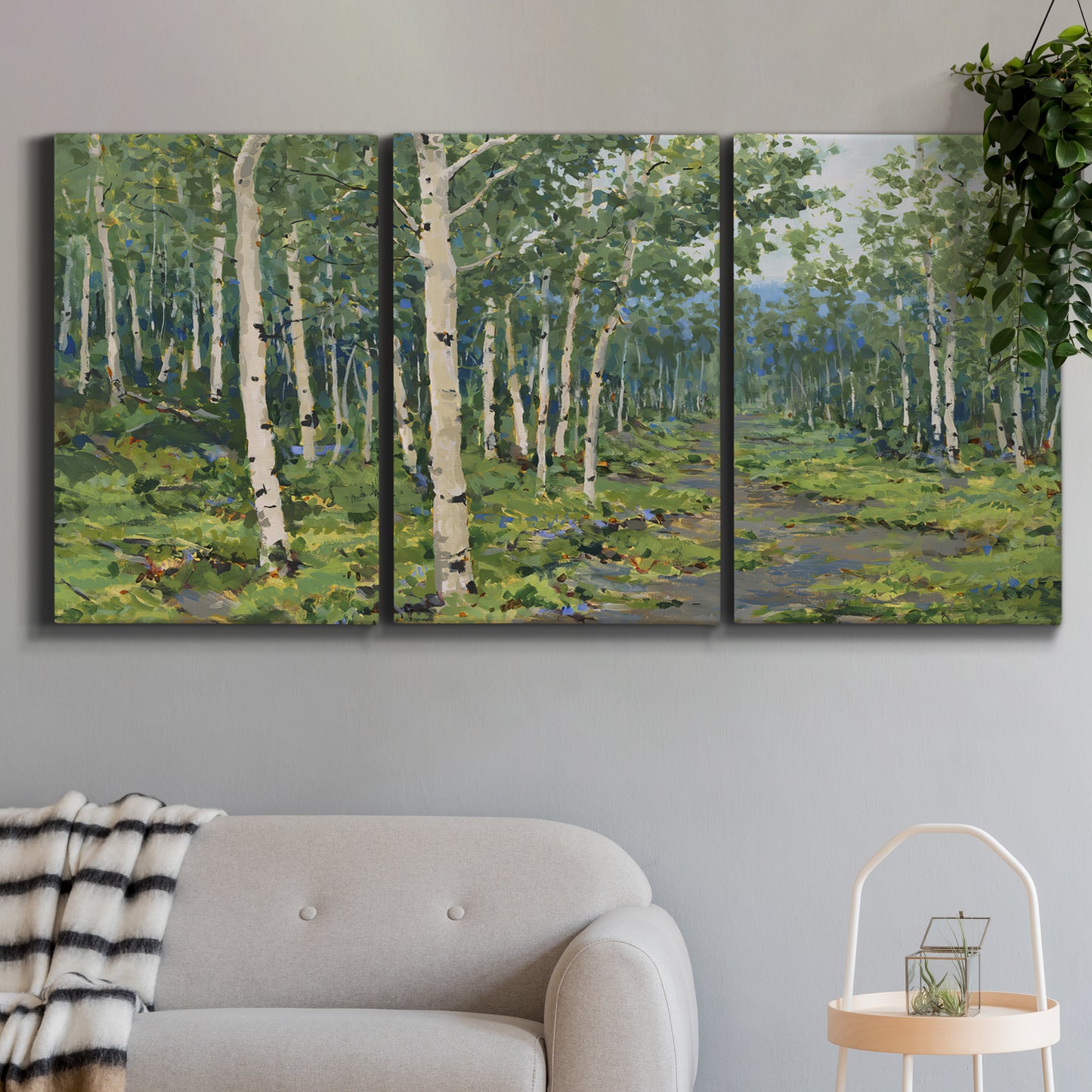 Three-panel canvas wall art featuring woodland forest scene with tall trees, displayed in a modern living room above a sofa.