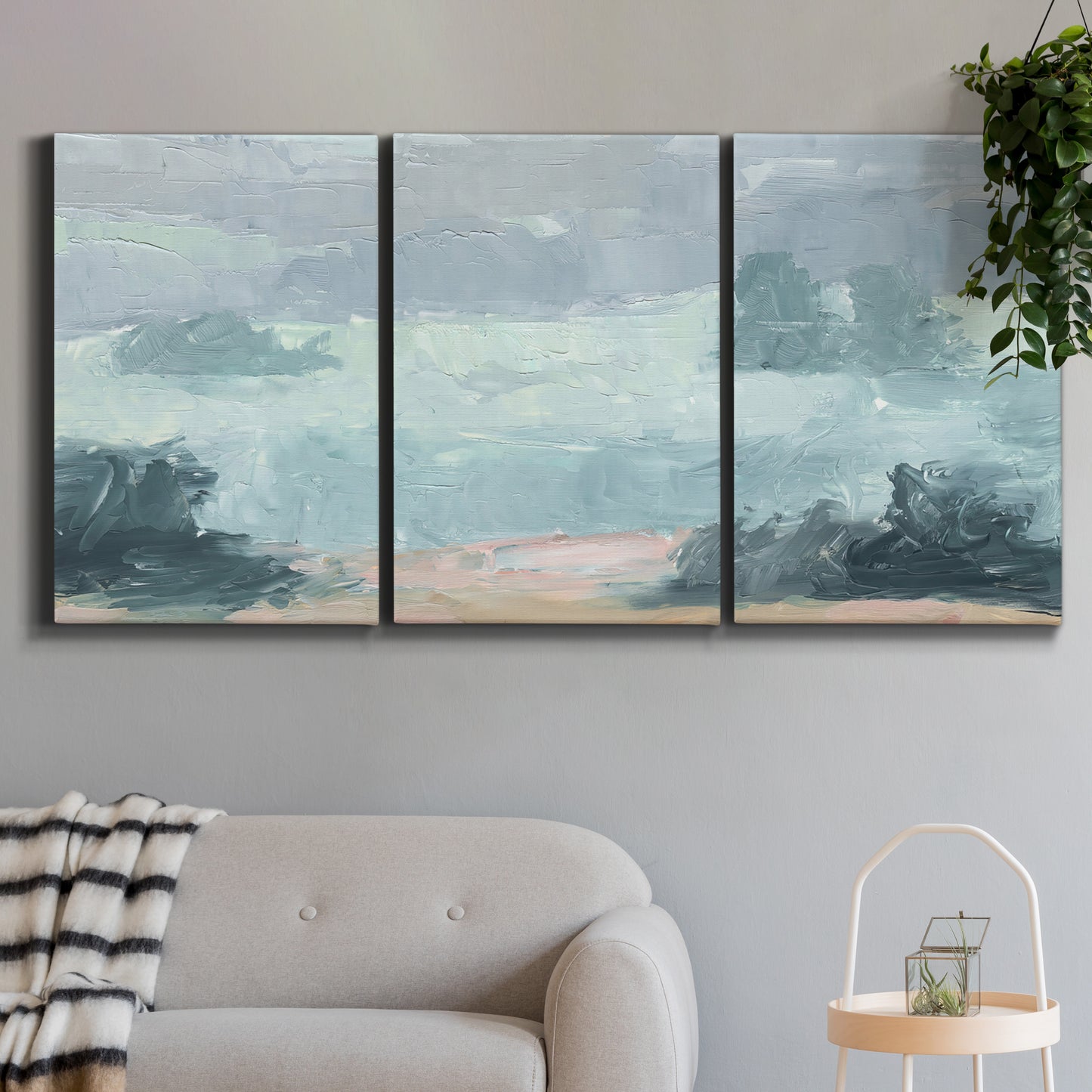 Three-panel canvas wall art featuring soft pastel valley landscape, displayed in a modern living room above a sofa.
