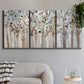 Three-panel canvas wall art featuring bare birch trees in winter forest, displayed in a modern living room above a sofa.