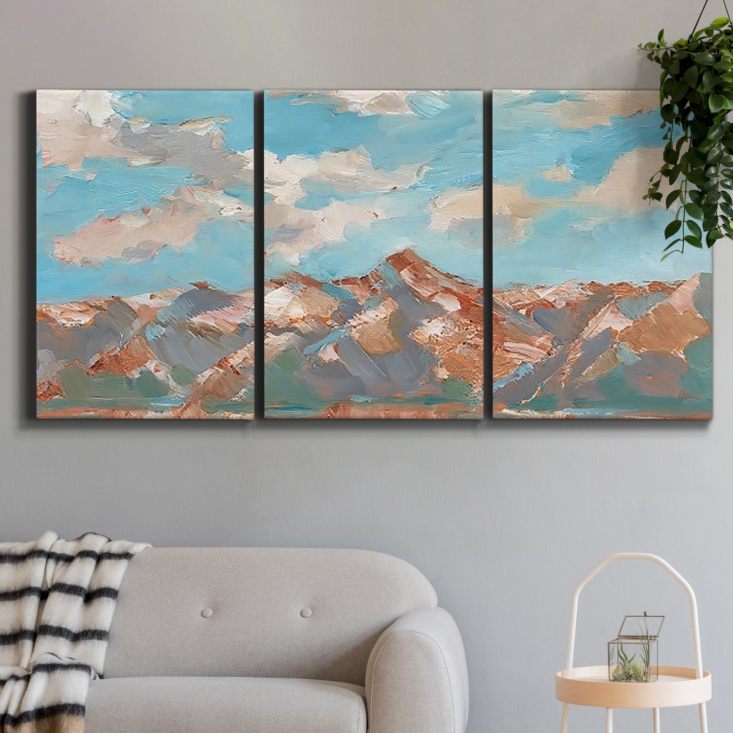 Three-panel canvas wall art featuring soft pastel western hills landscape, displayed in a modern living room above a sofa.