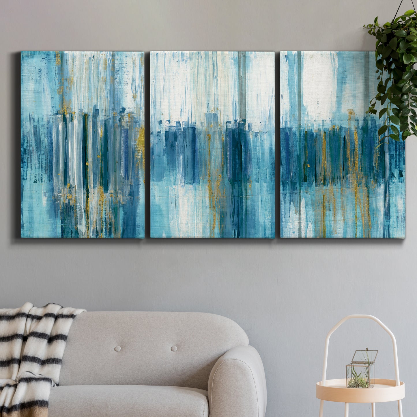 Three-panel canvas wall art featuring layered abstract earth tones, displayed in a modern living room above a sofa.