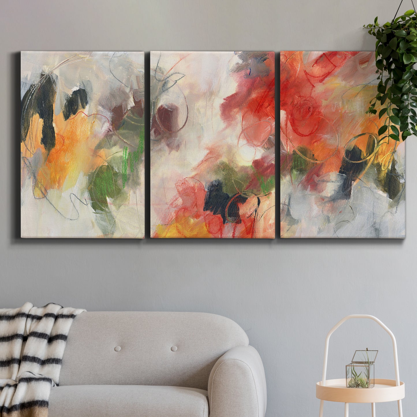 Three-panel canvas wall art featuring abstract floral color composition, displayed in a modern living room above a sofa.